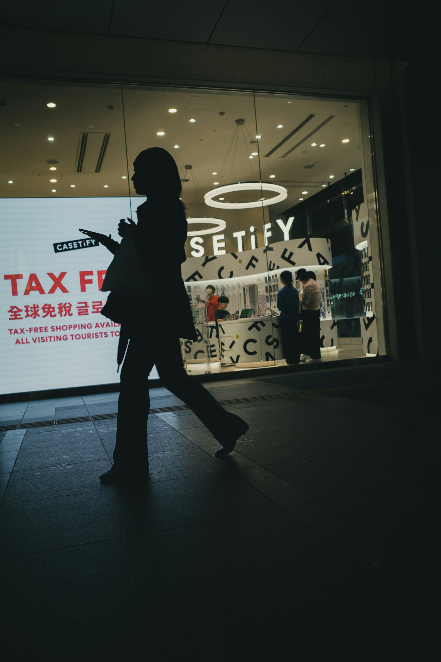 走過商店的輪廓人物與明亮的標識