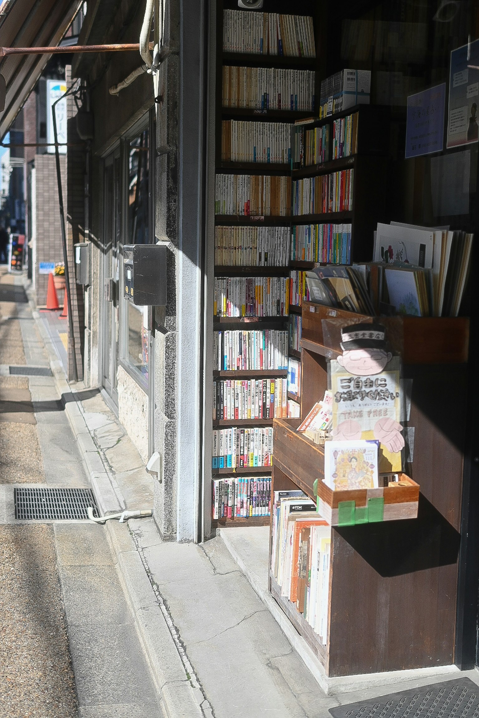 Esterno di una libreria di seconda mano con libri sugli scaffali e luce solare che entra