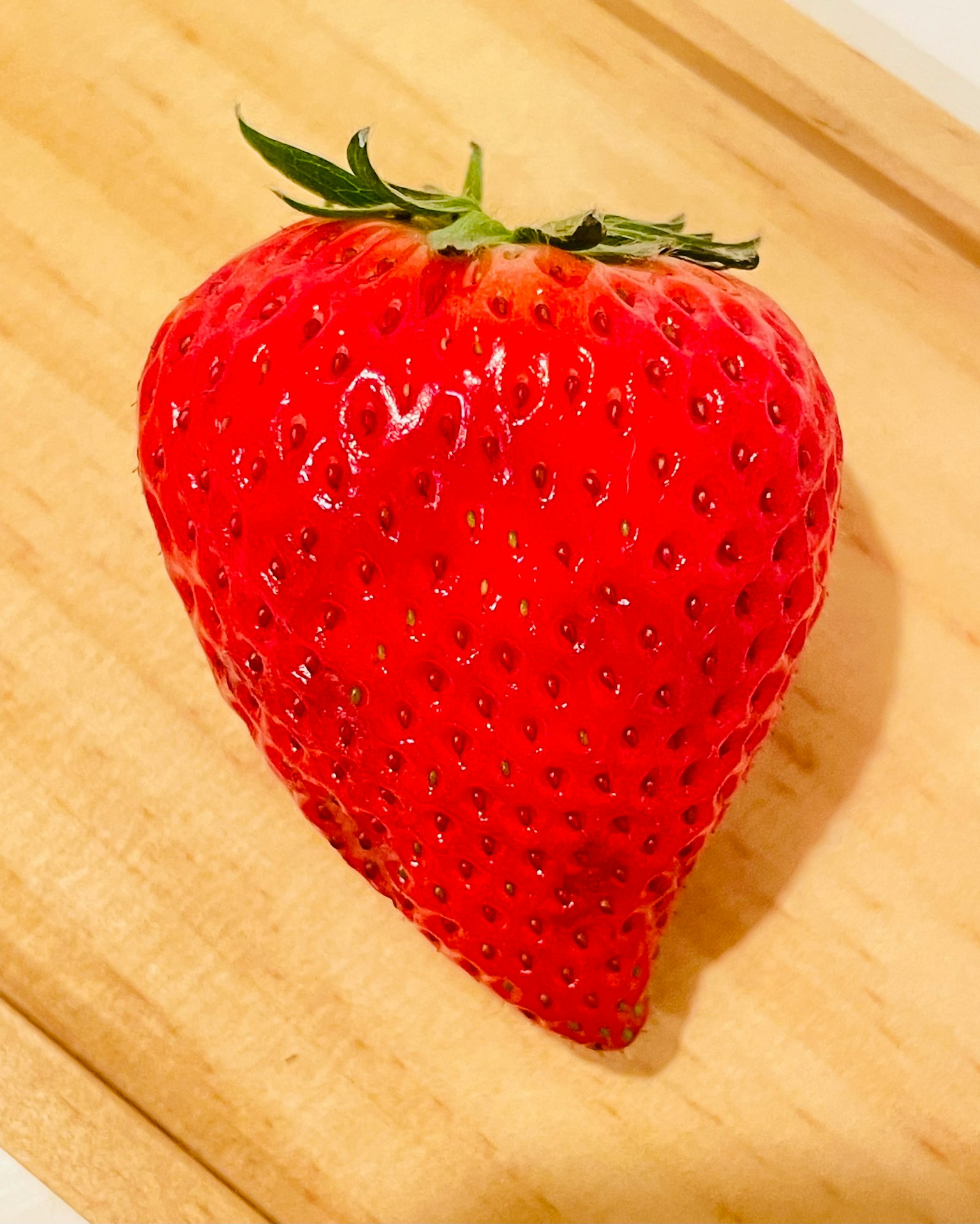 Strawberry merah cerah diletakkan di atas papan kayu