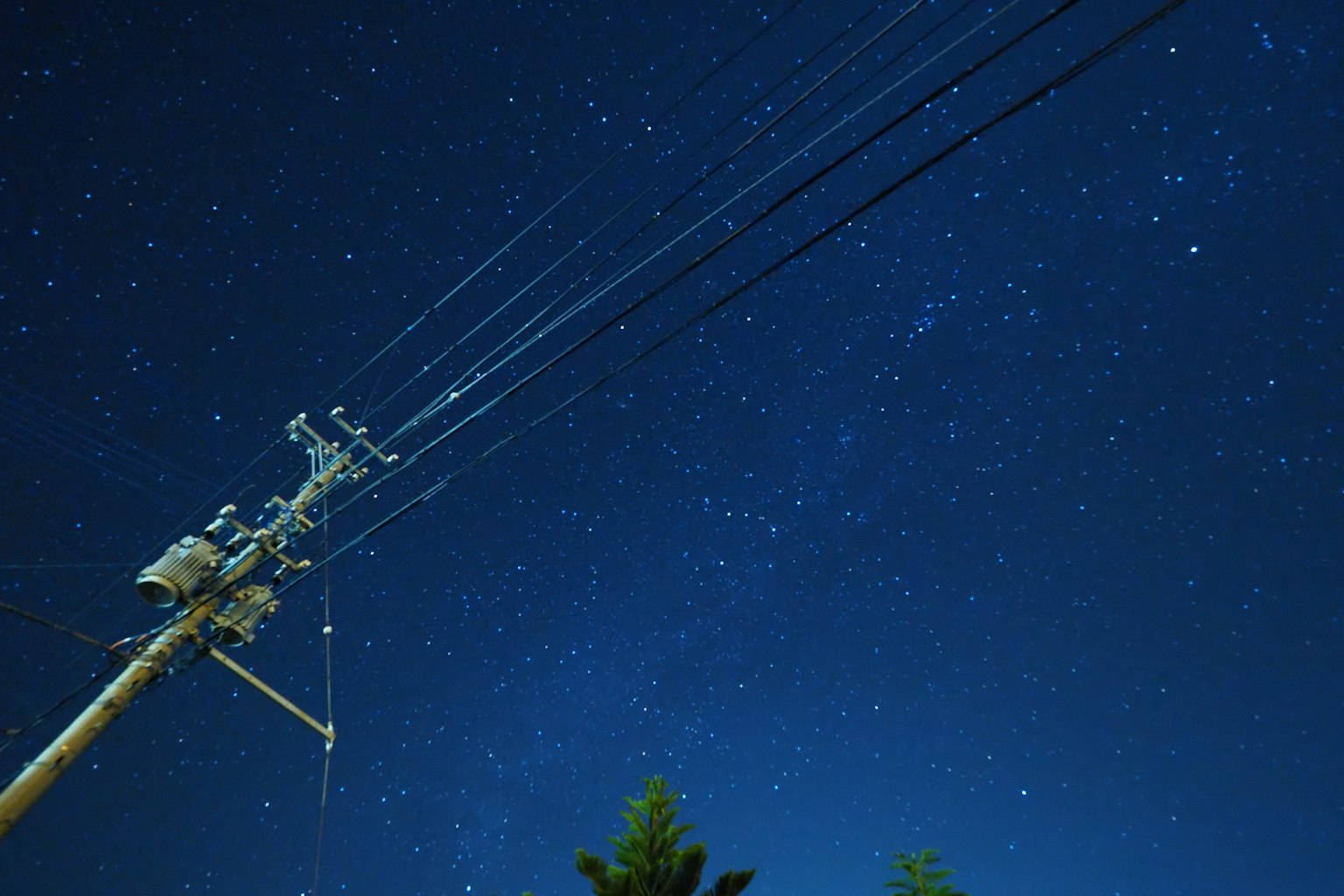 Nachthimmel voller Sterne und ein Strommast