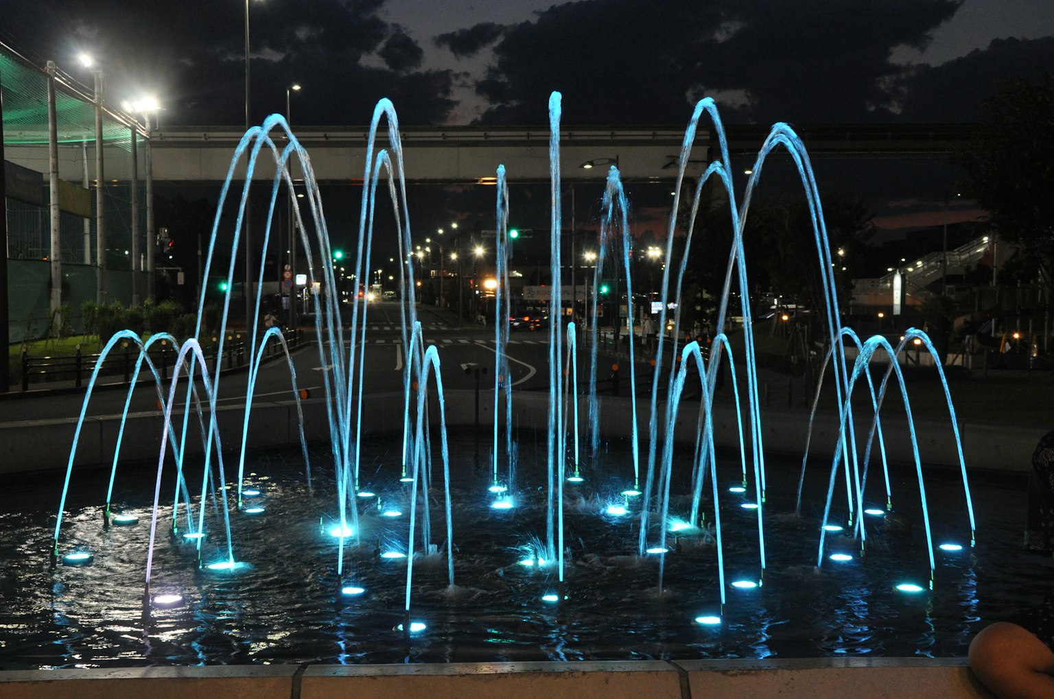 Nachtfontäne mit beleuchteten blauen Wasserstrahlen