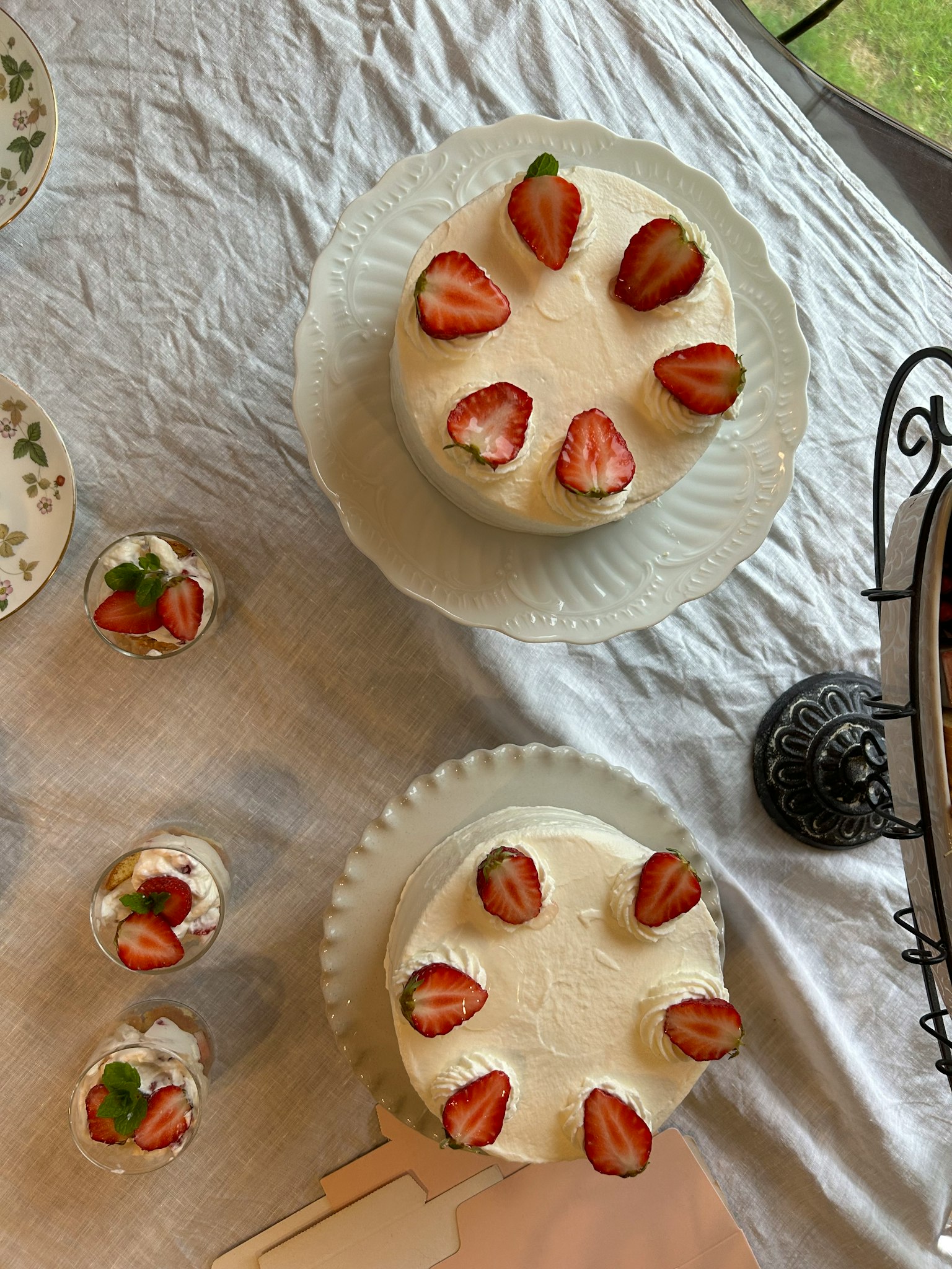 Dua kue bulat dihiasi stroberi di atas meja putih