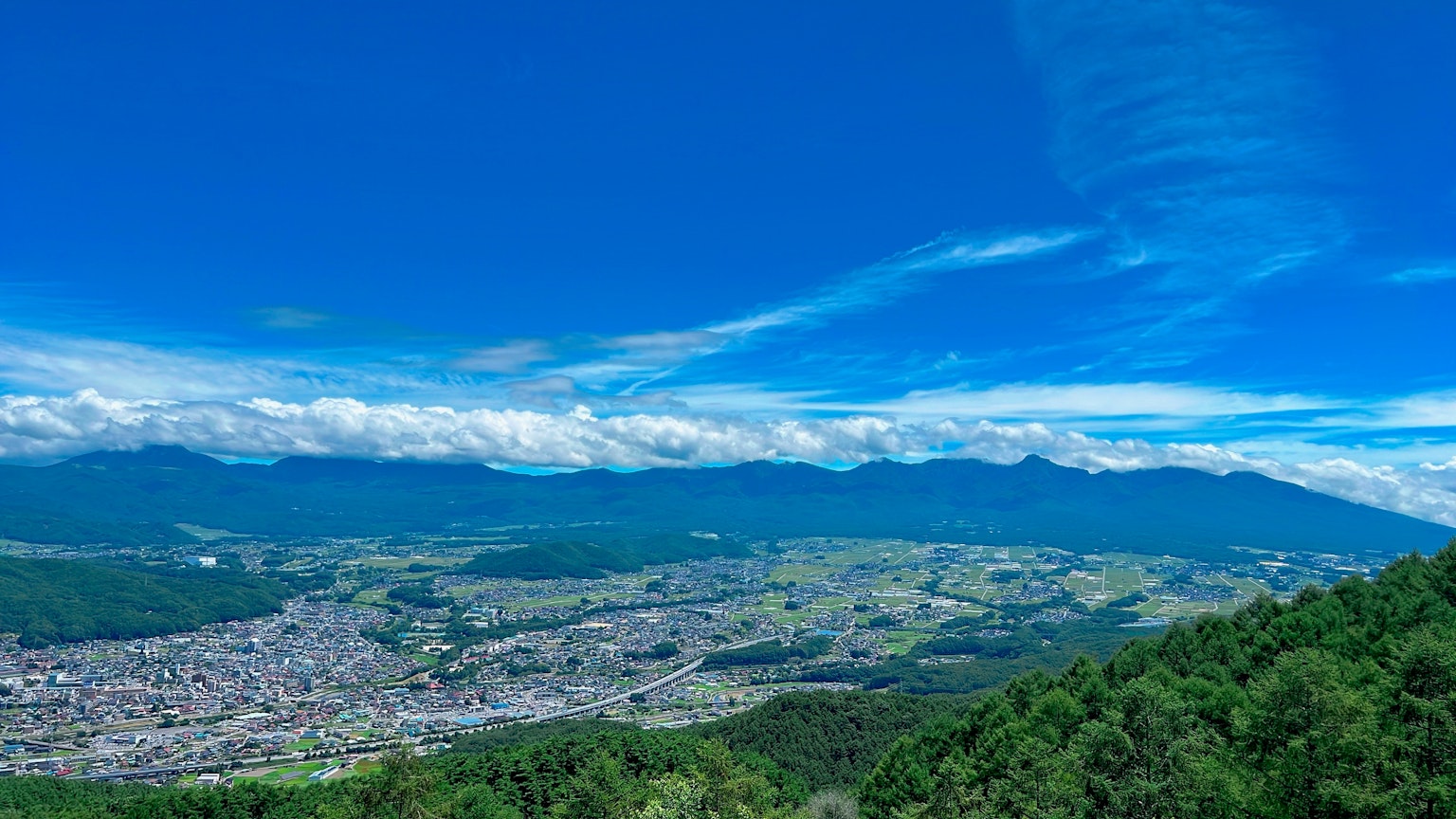 清澈藍天和白雲下的山脈和山谷的全景