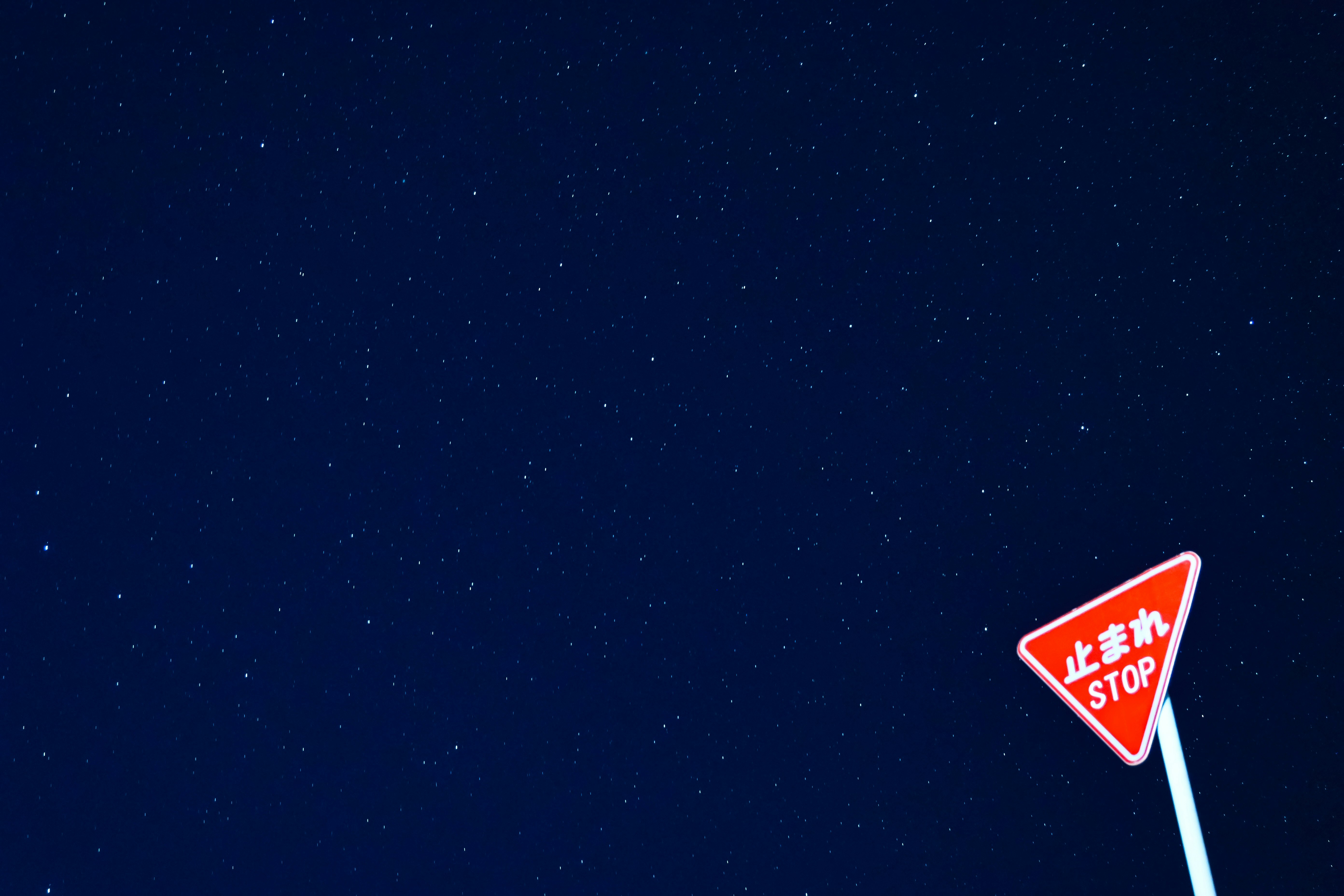 langit malam berbintang dengan rambu stop di sudut jalan