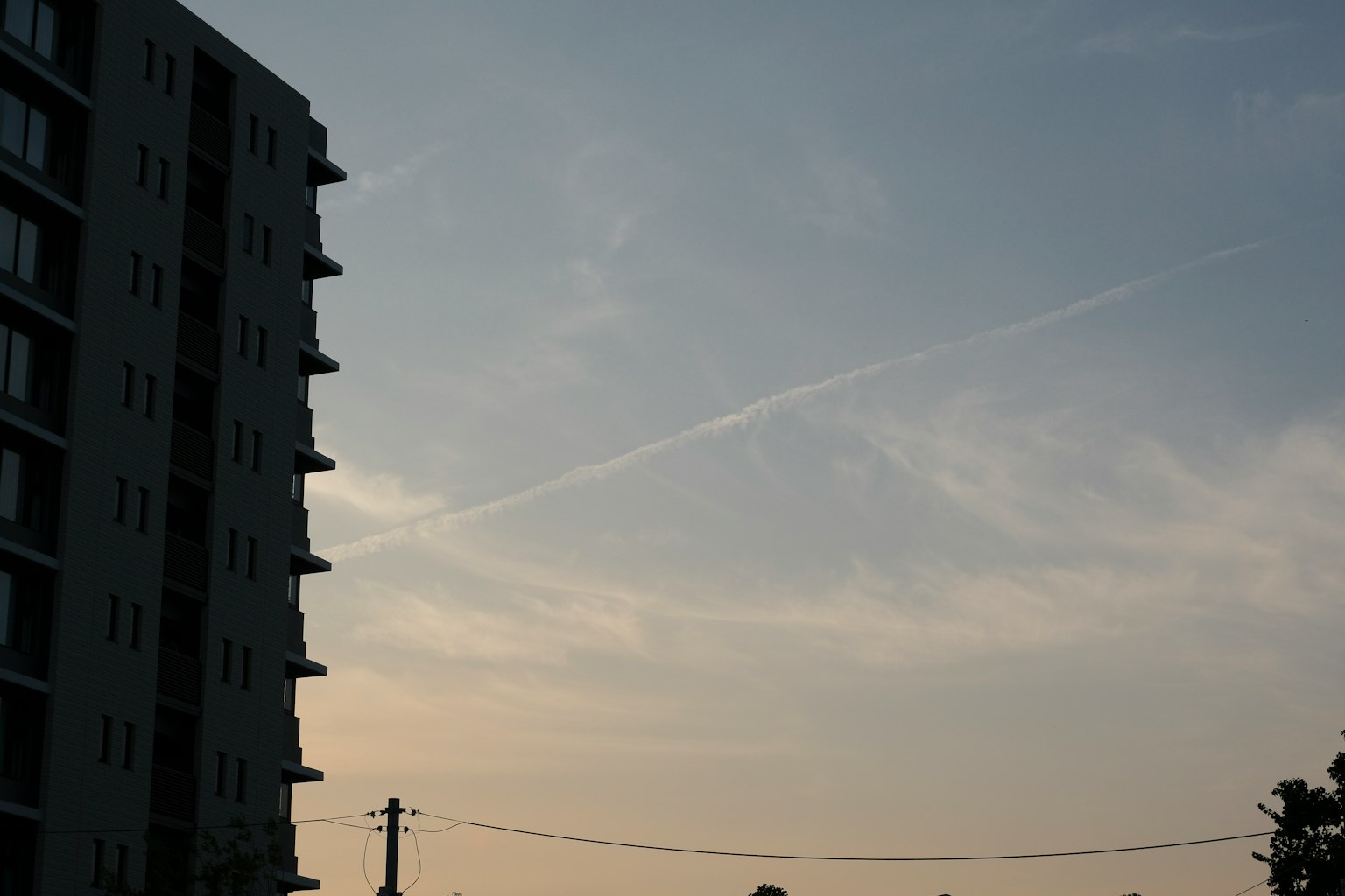 Silhouette di un edificio alto contro un cielo blu con nuvole