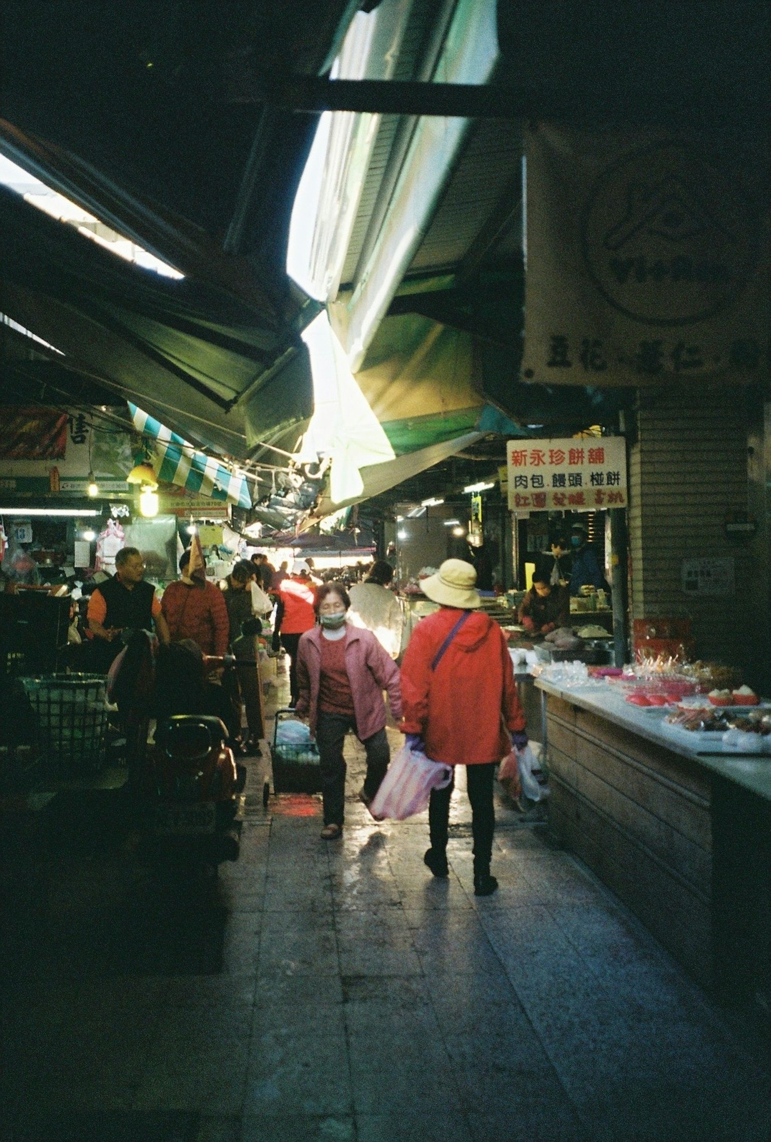 Personas caminando en una calle de mercado con luz brillante