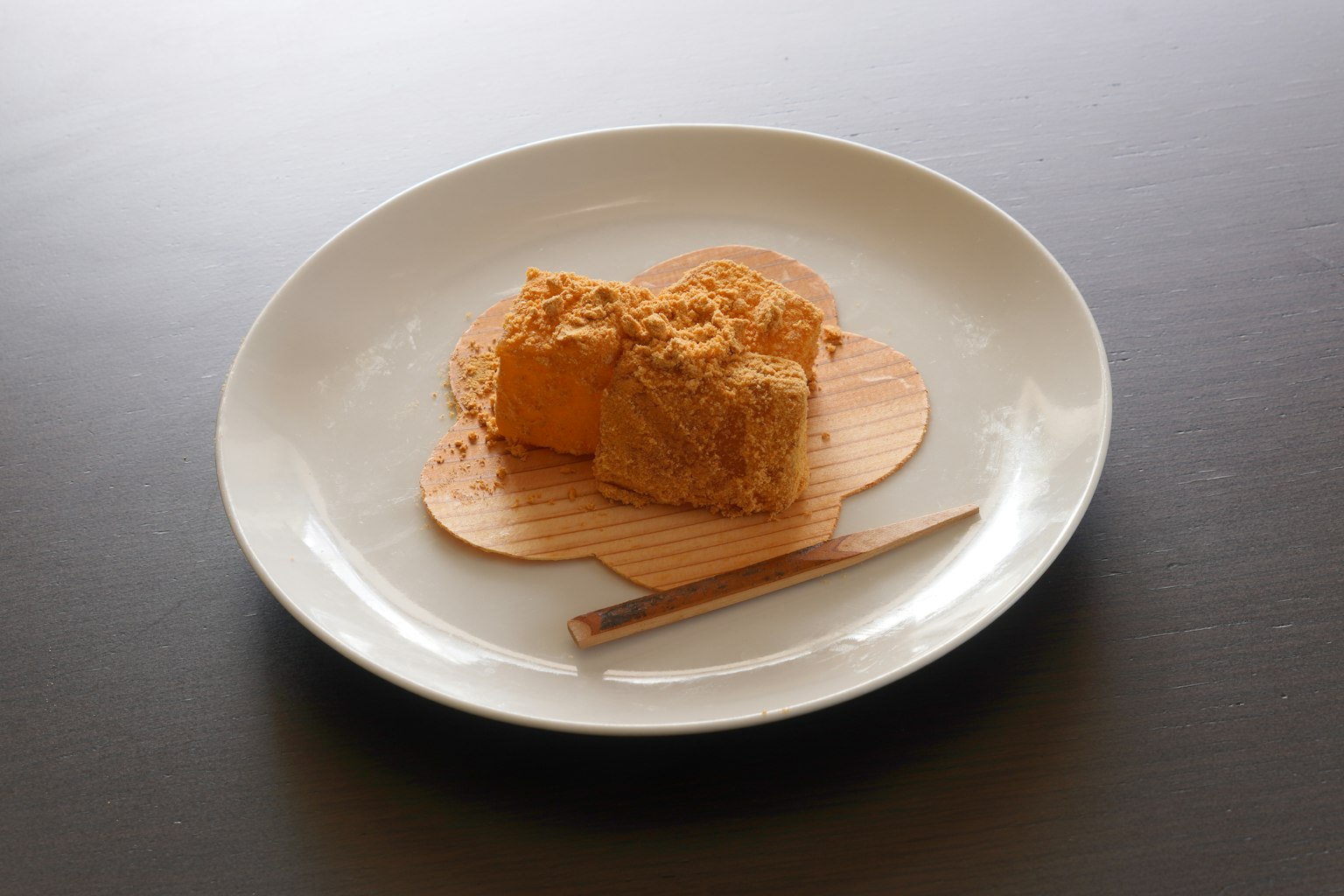 Dessert a base di farina di soia su un piatto bianco con un cucchiaio di legno