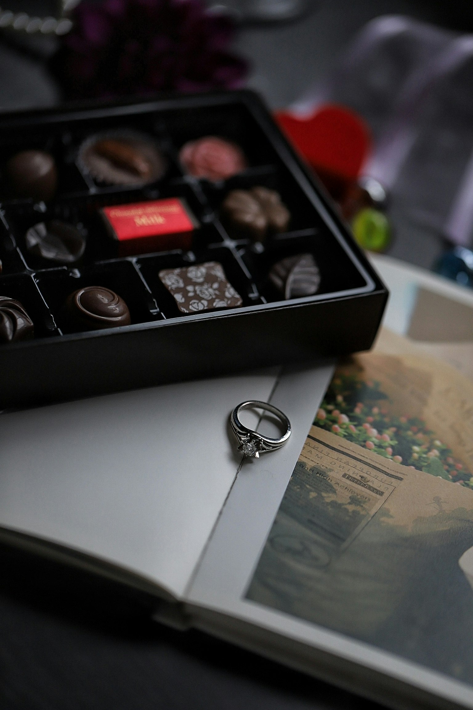 Livre ouvert avec une bague de mariage et une boîte de chocolats