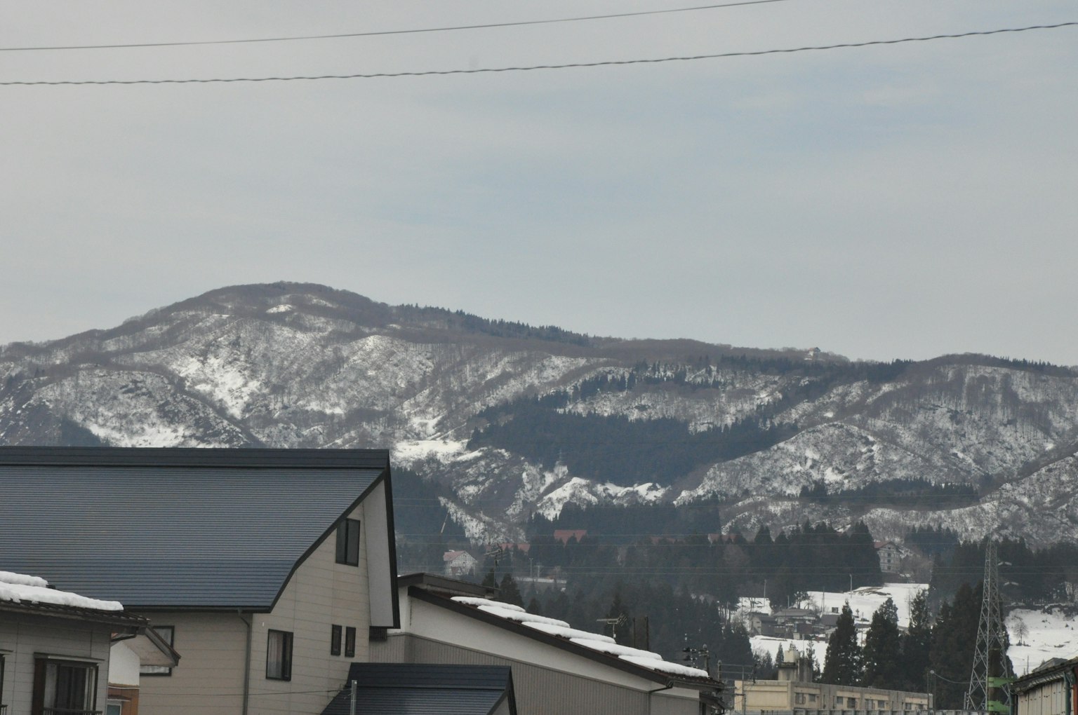 Montañas cubiertas de nieve al fondo con una zona residencial en primer plano