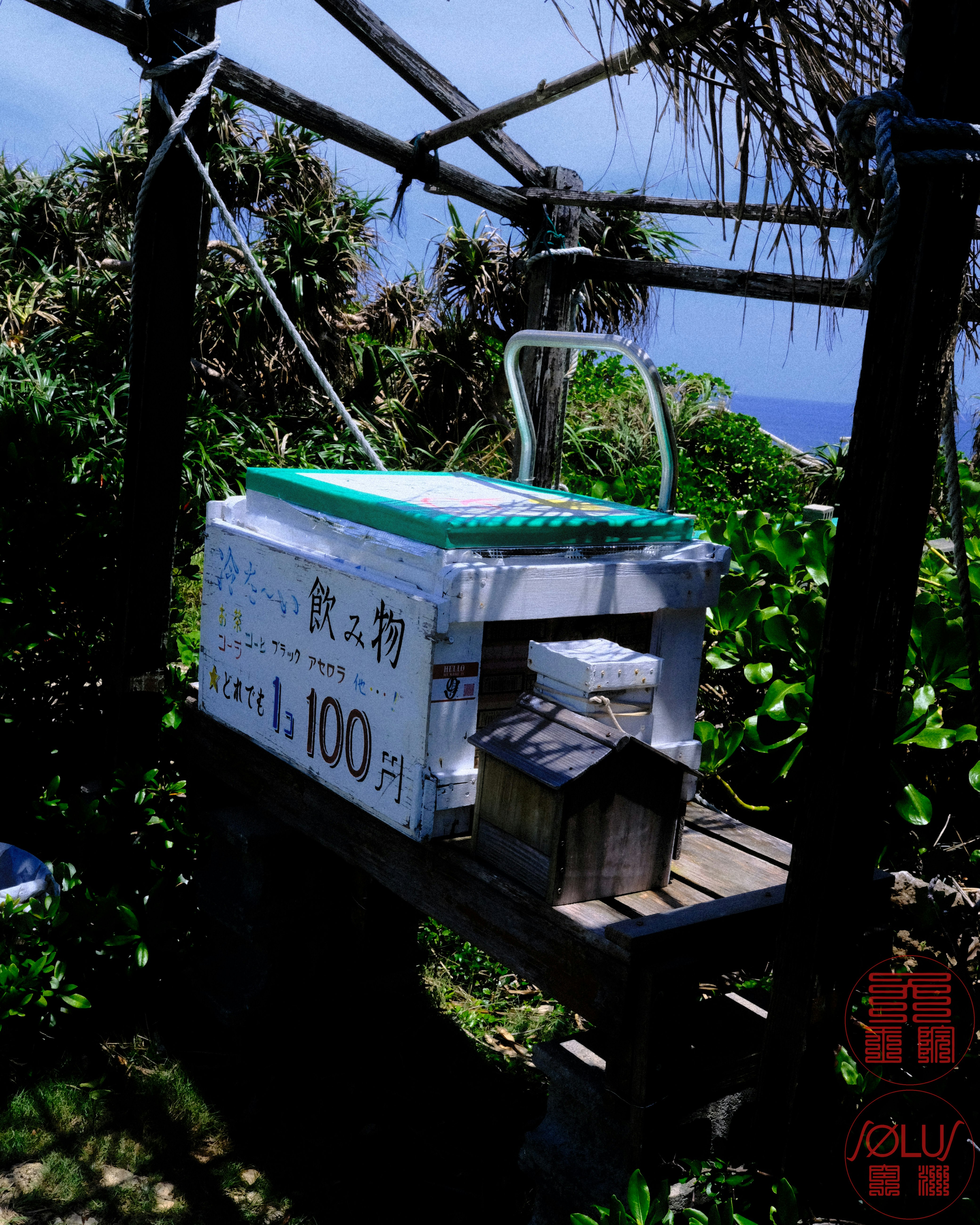 海边小路上树荫里的小型售卖箱与自行车