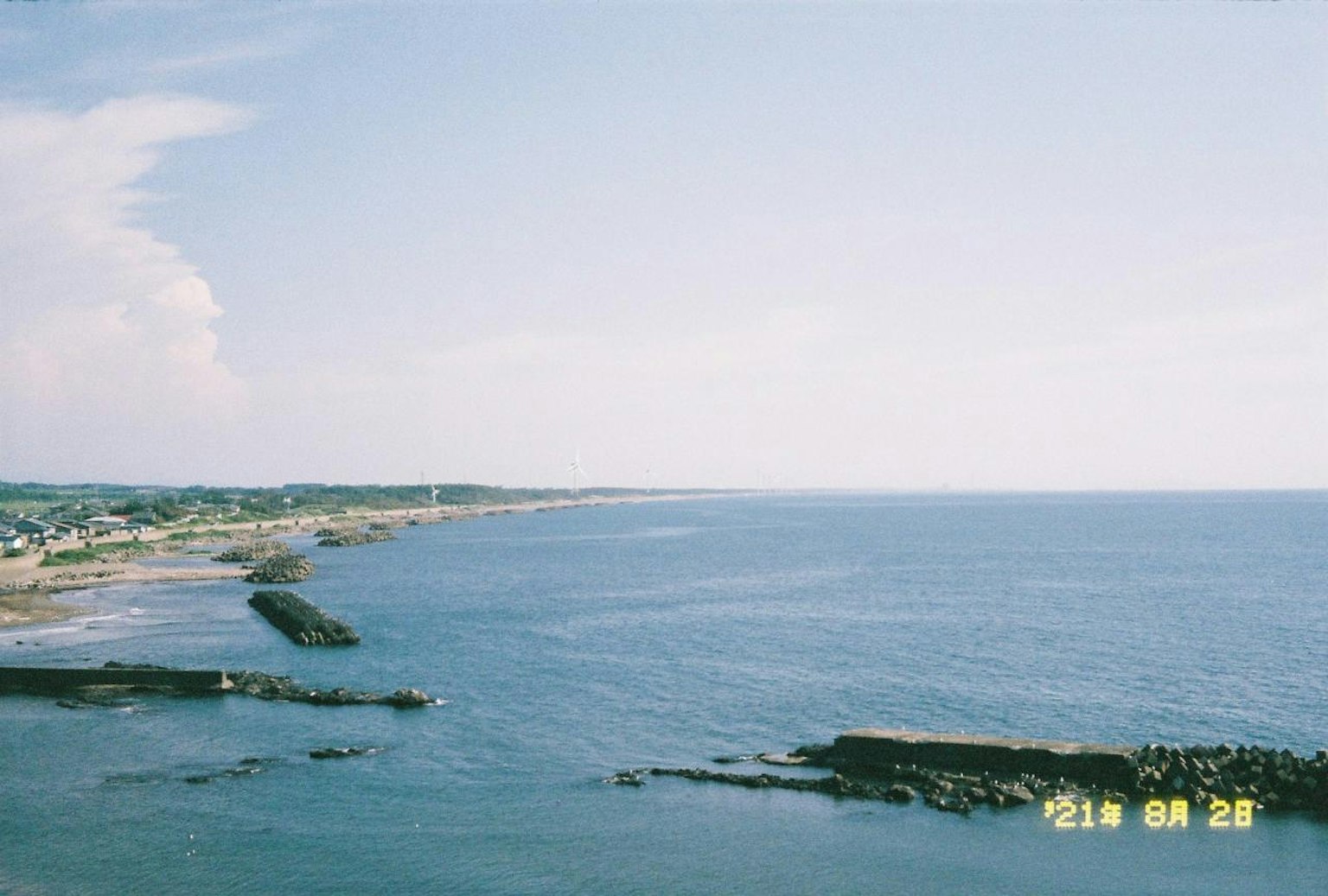 Vue panoramique de la mer et du ciel bleus avec la côte et des brise-lames