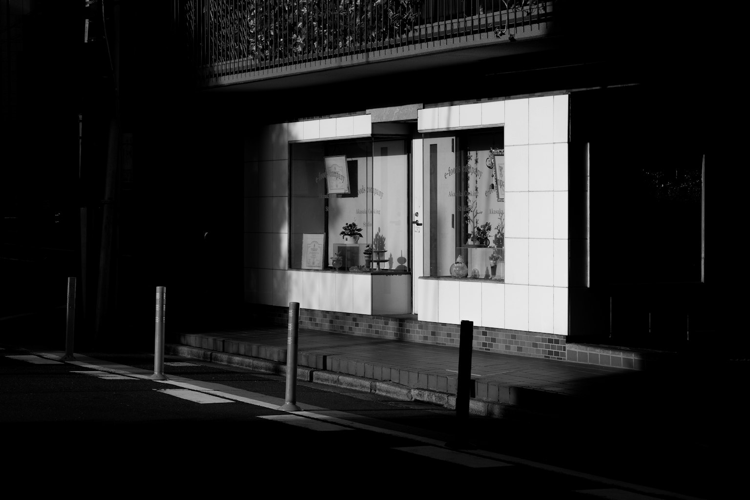 A storefront with white exterior in a dark street setting