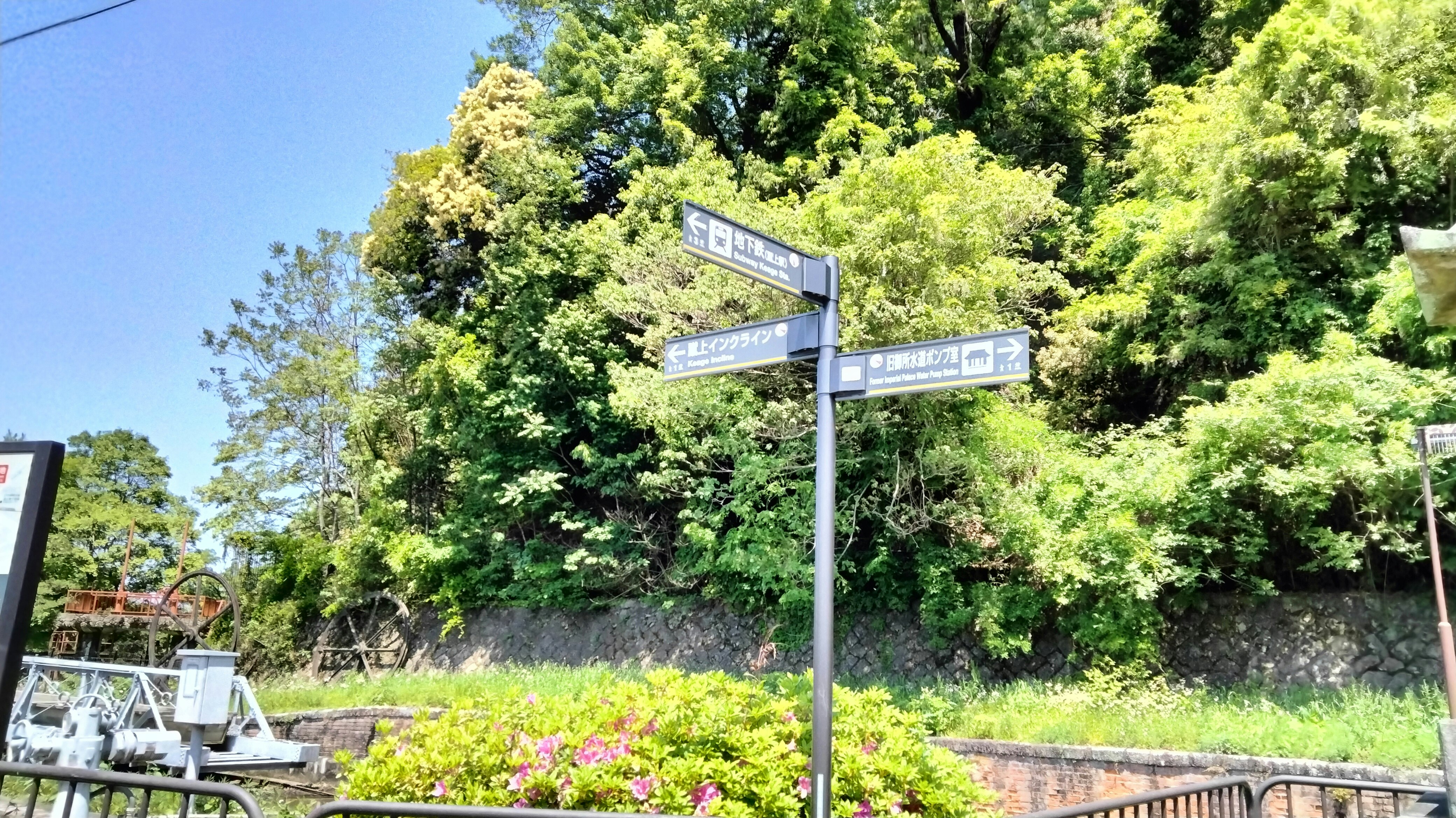 緑の斜面に設置された道案内標識のある風景