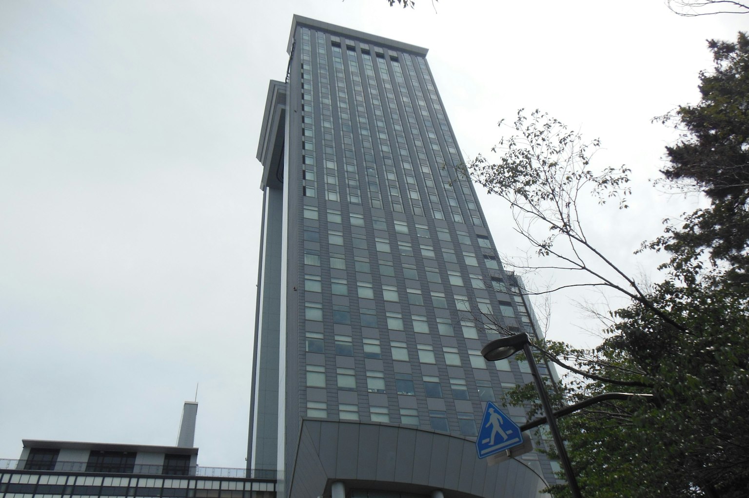 高层建筑的图像，具有灰色外立面和许多窗户