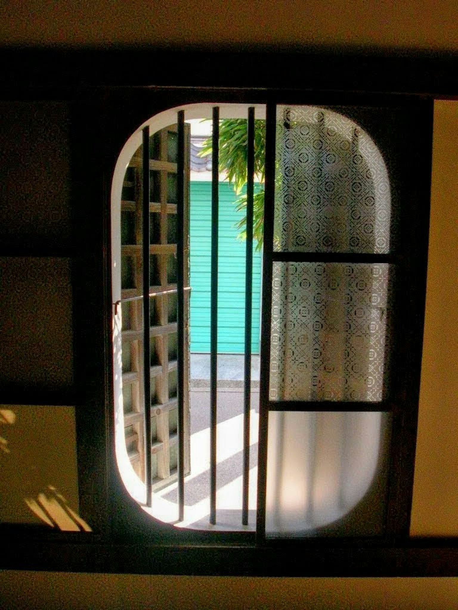 Traditionelles japanisches Fenster mit Blick auf eine grüne Tür und Licht