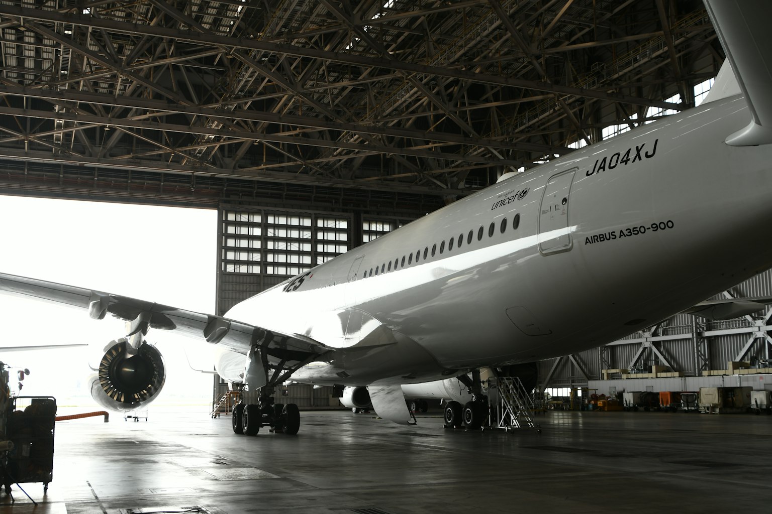 飛機停在機庫內，展示其引擎和機翼