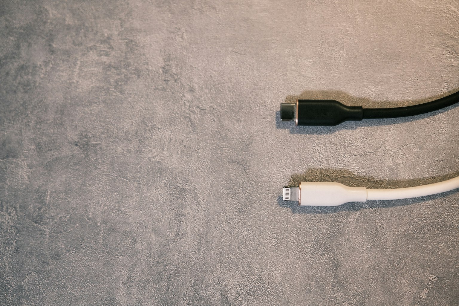 Câbles noir et blanc posés sur une surface grise