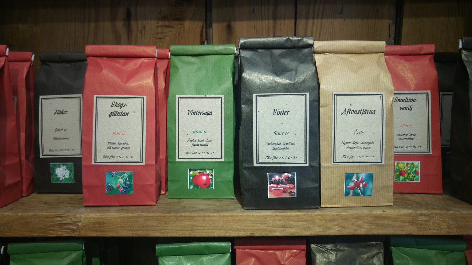 Estantes que exhiben bolsas de café en empaques rojo, verde, negro y marrón
