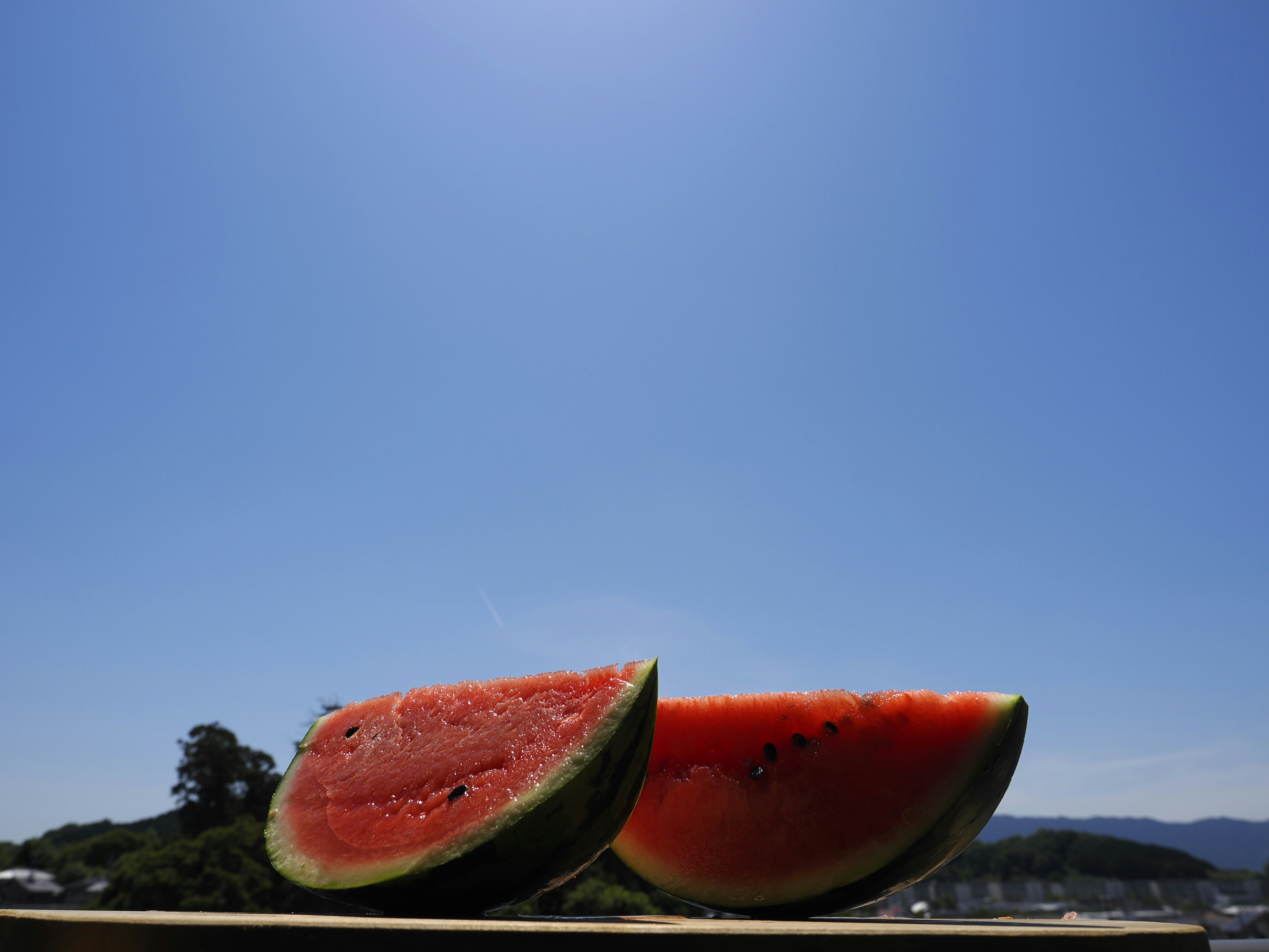 夏空の下で並ぶスイカの果肉と赤い果実