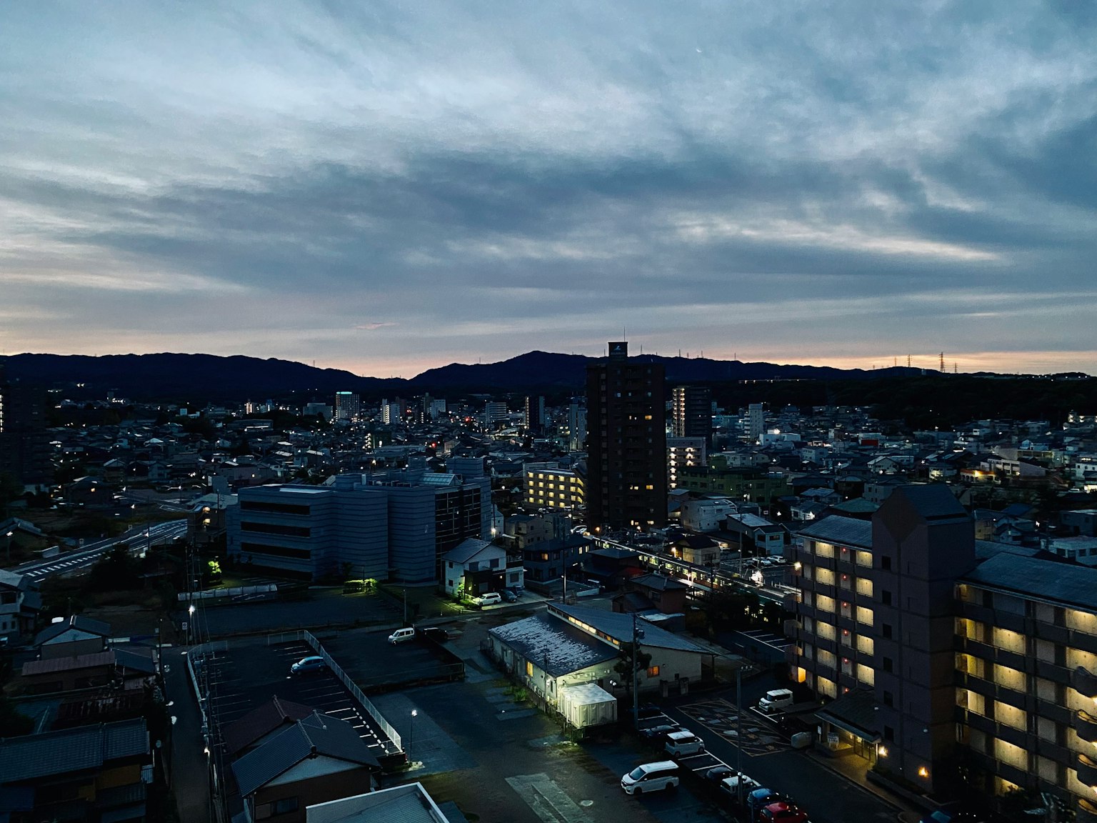 Urban landscape at dusk with silhouettes of mountains