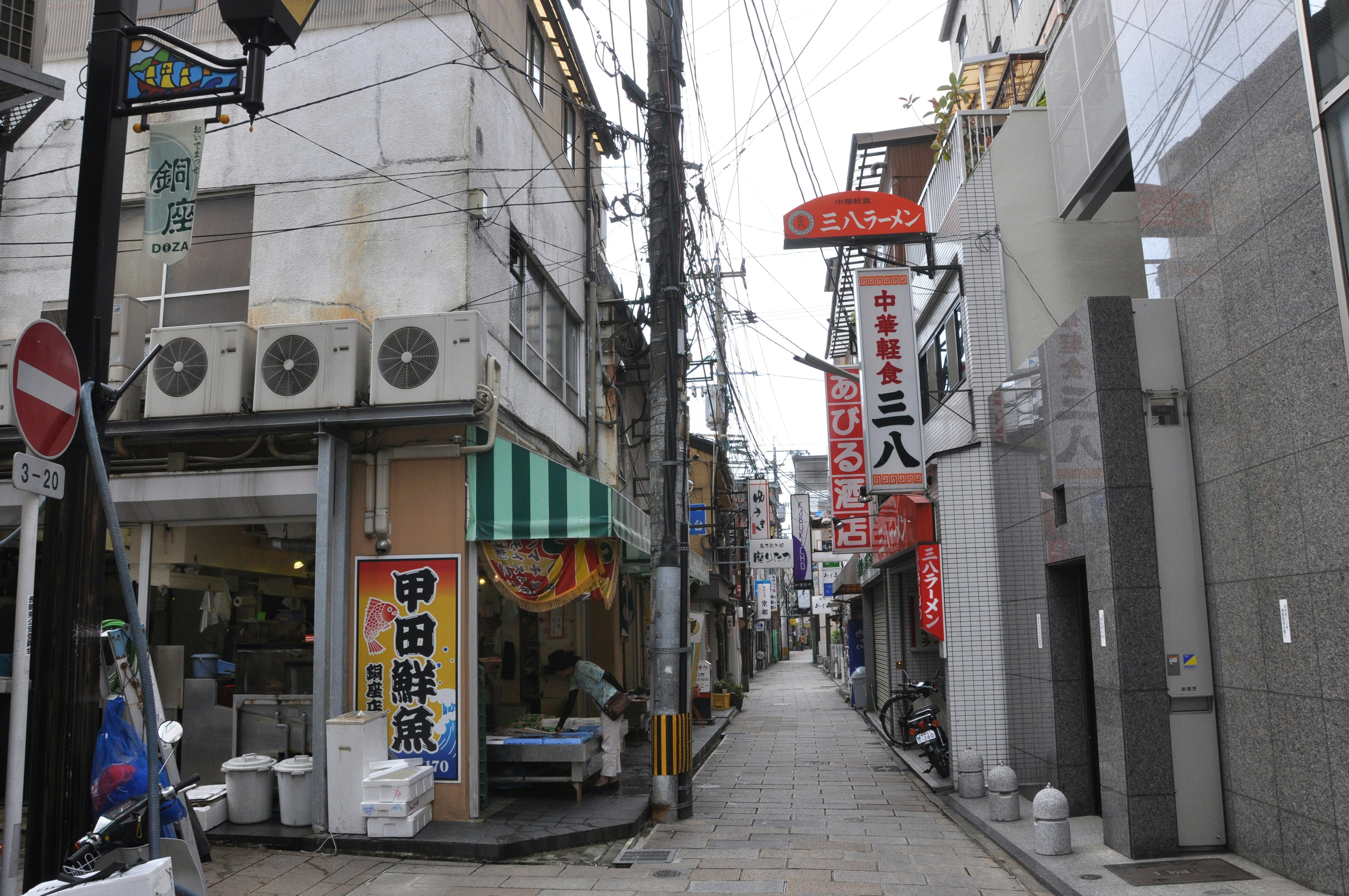 狹窄巷弄兩側的店鋪招牌與腳踏車