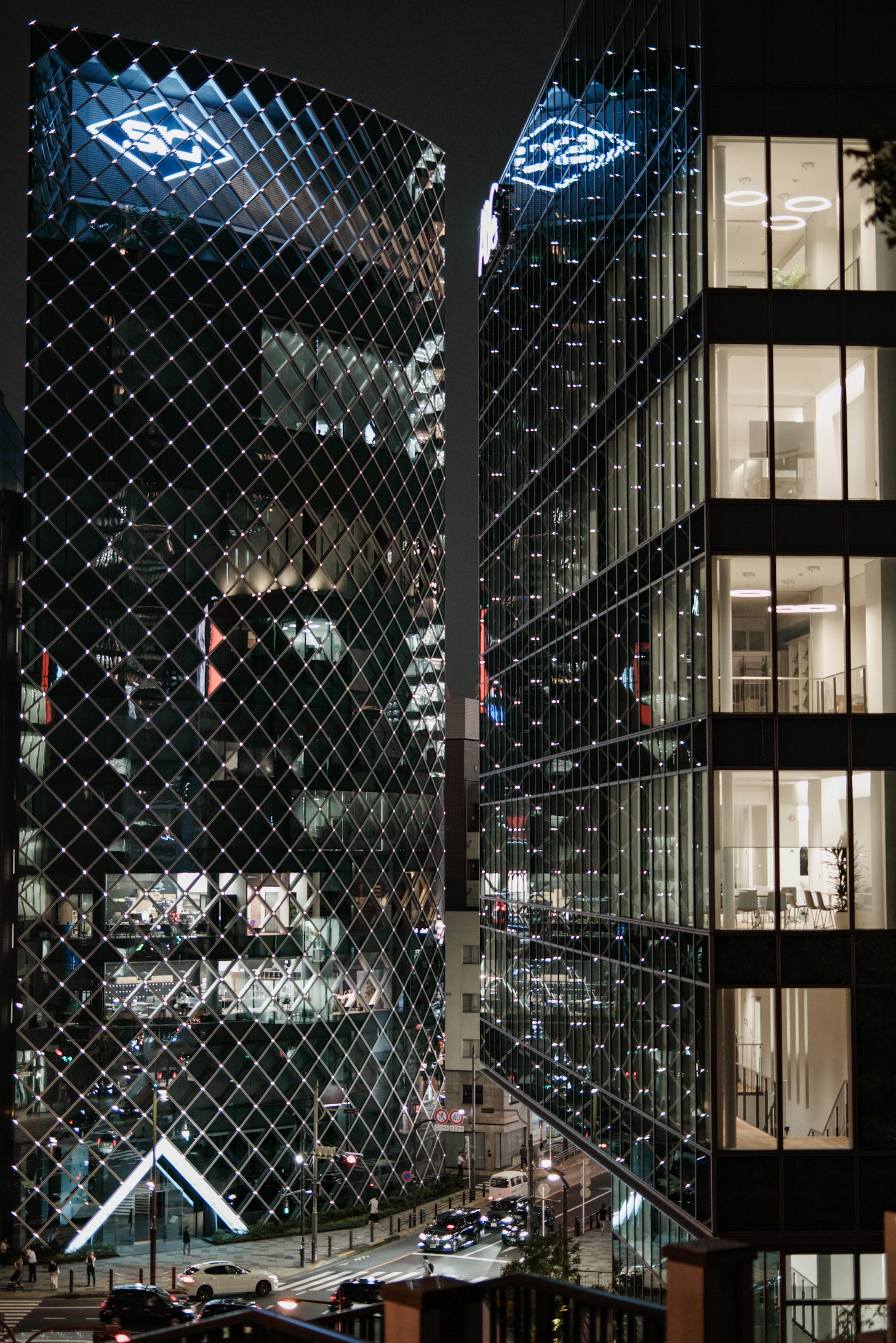 Moderne Wolkenkratzer bei Nacht beleuchtet mit Glasfassaden und einzigartigem architektonischen Design