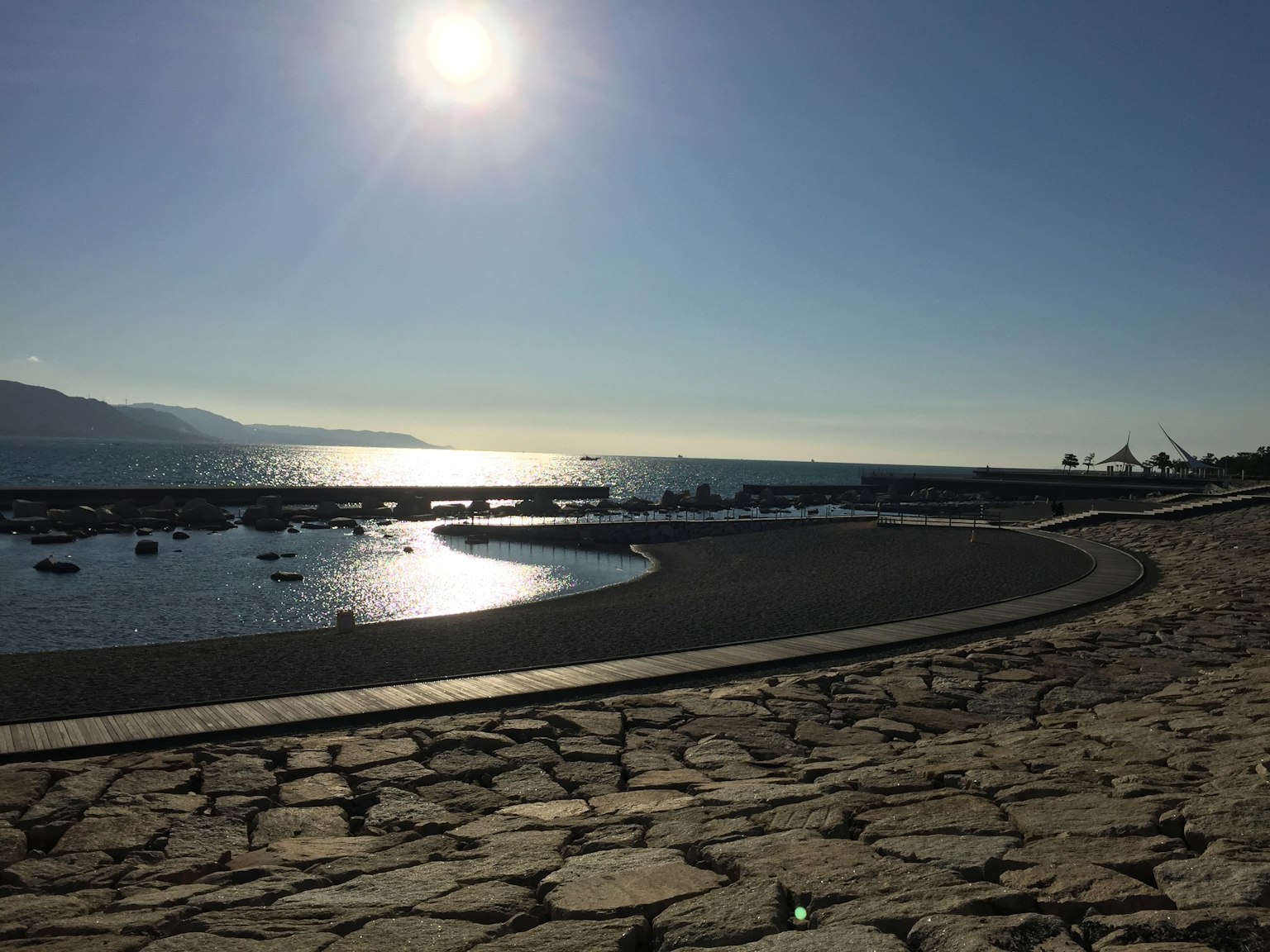 Costa serena con la luce del sole che si riflette sull'acqua
