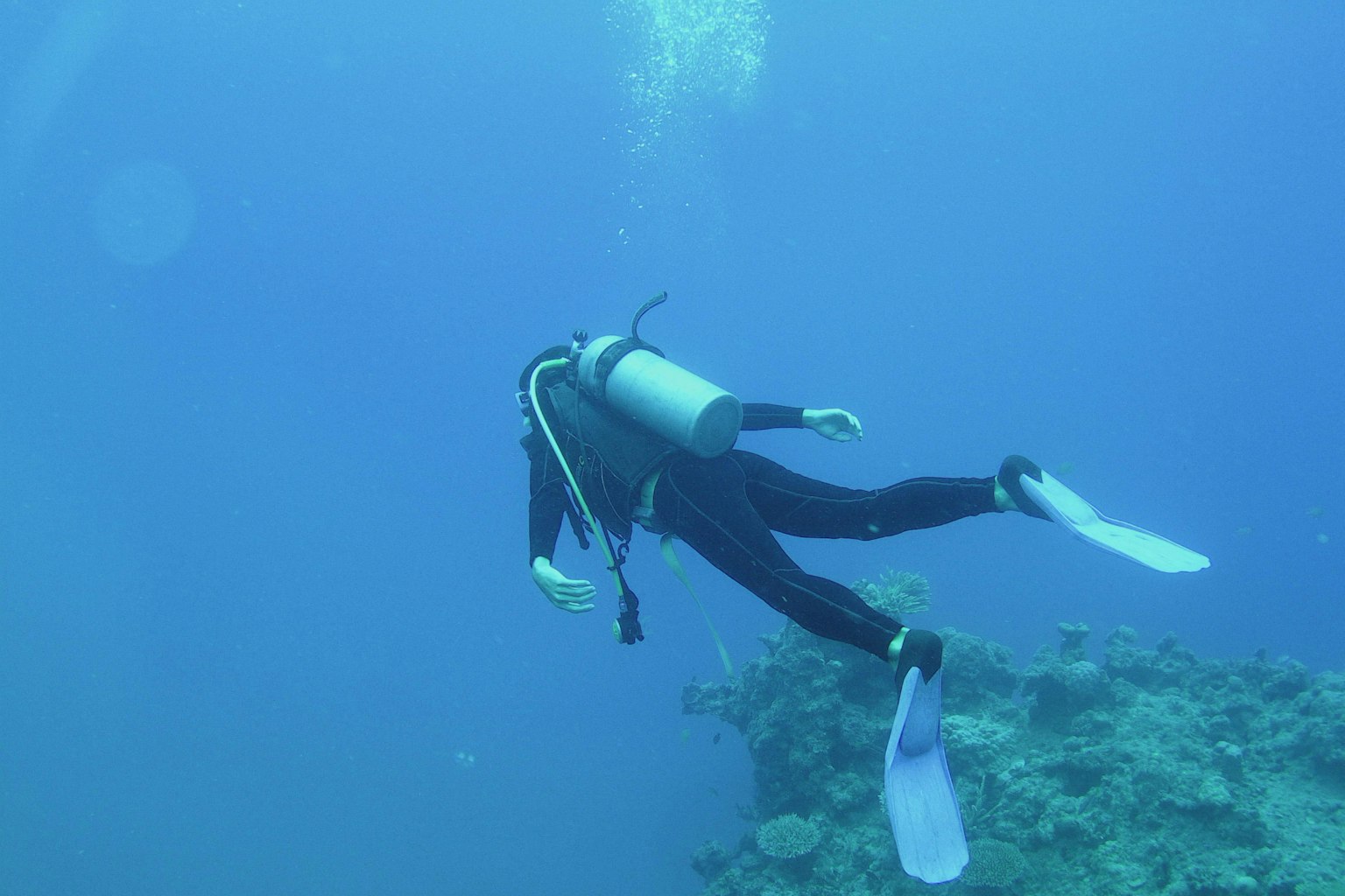 Buzo nadando en el océano azul profundo