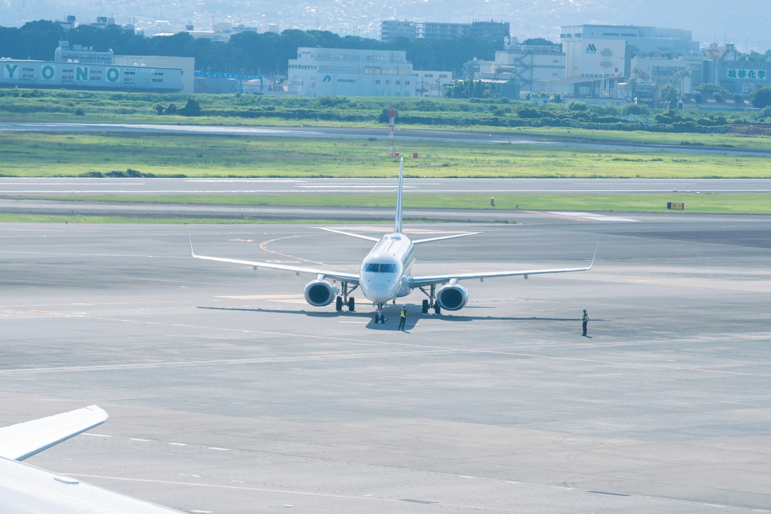 Airplane on the runway at an airport viewed from behind