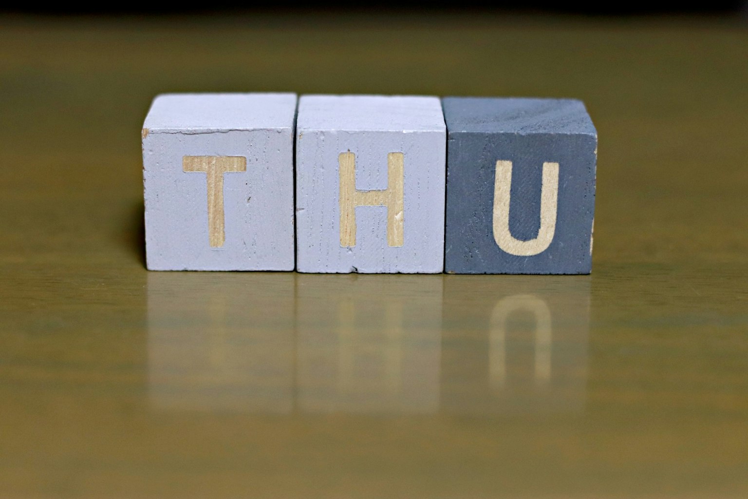 บล็อกไม้ที่แสดงตัวอักษร "THU"