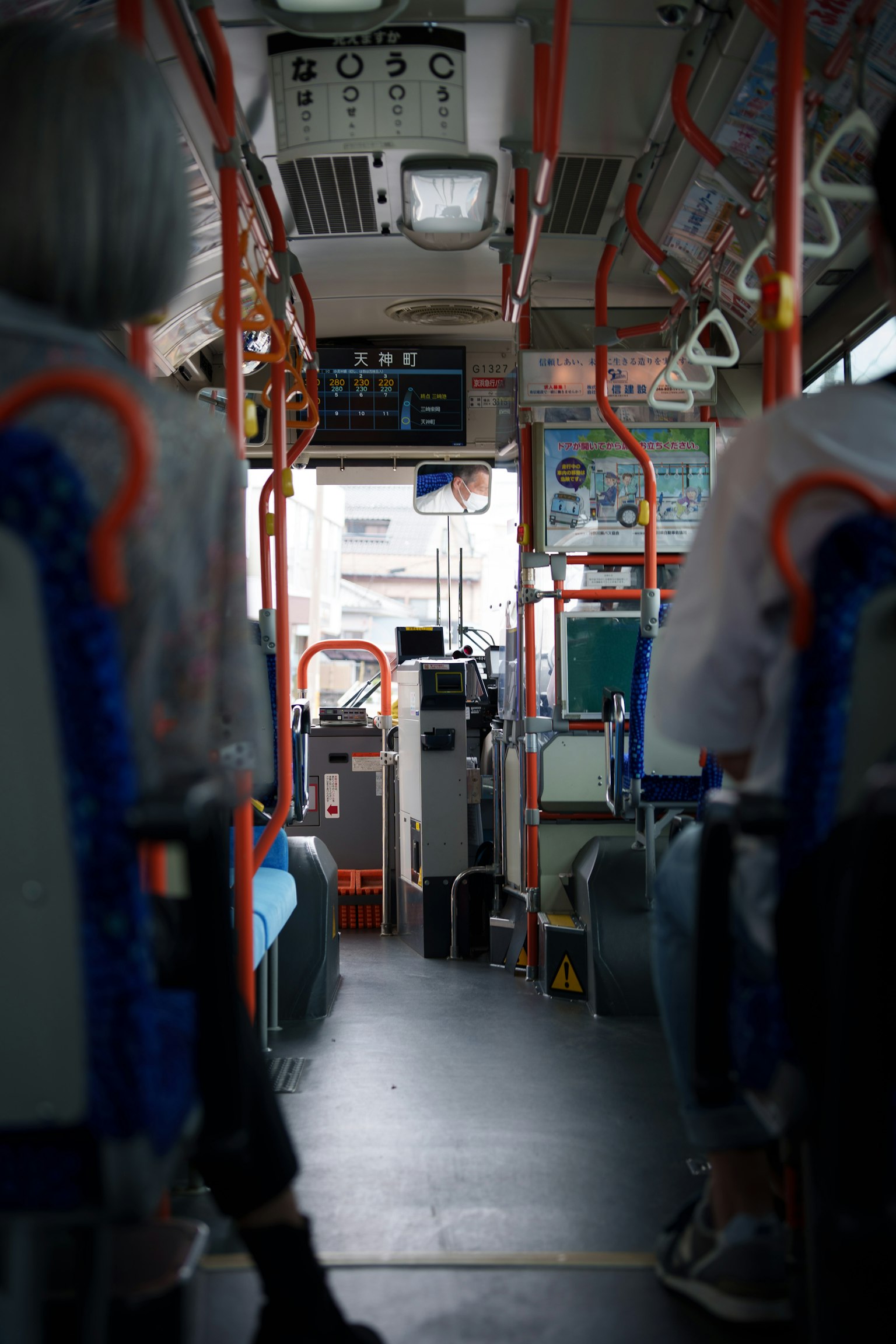 Vue intérieure d'un bus regardant vers le siège du conducteur depuis les sièges arrière