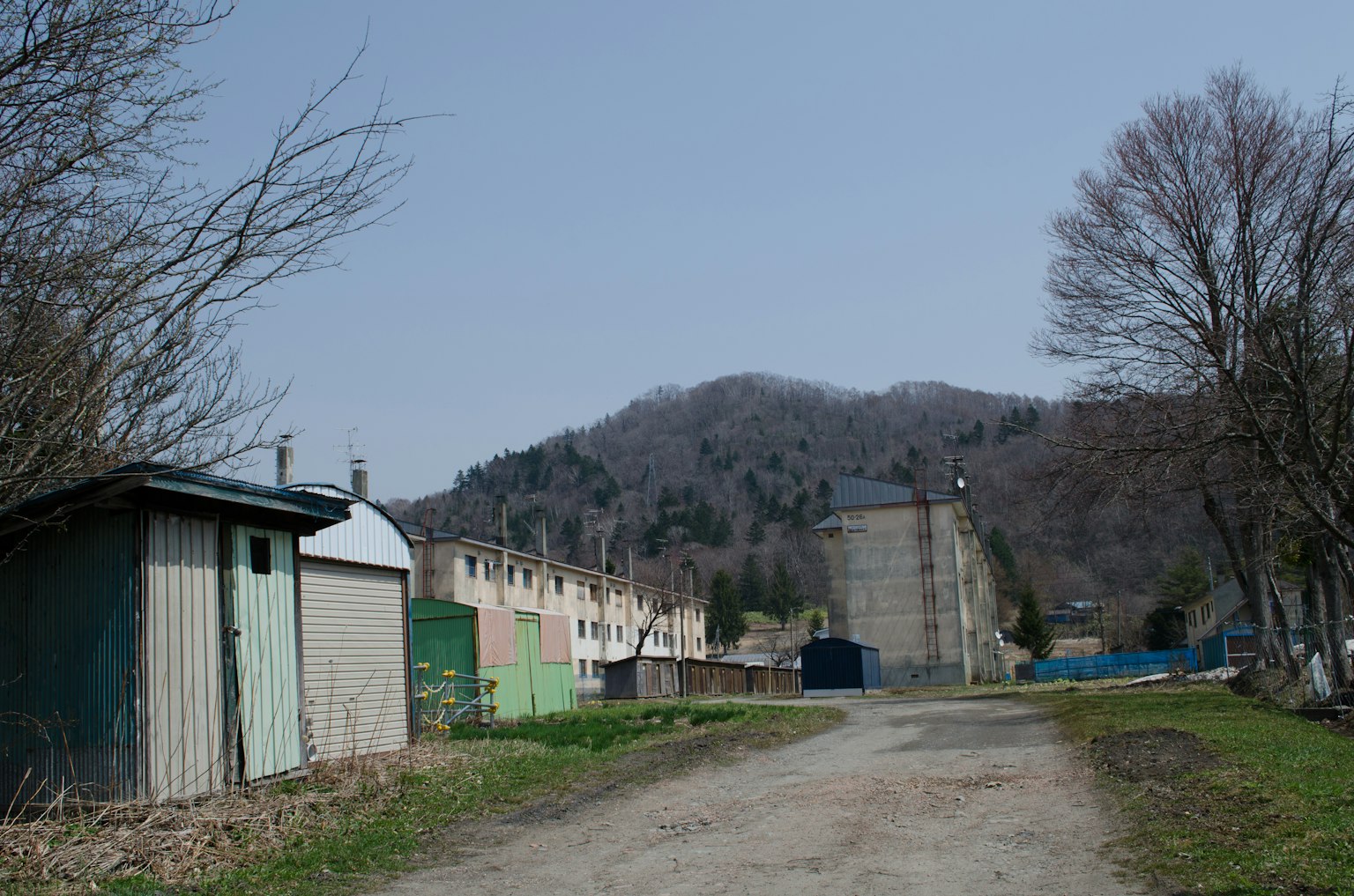 Ruhige Landstraße mit alten Gebäuden und Bergen im Hintergrund
