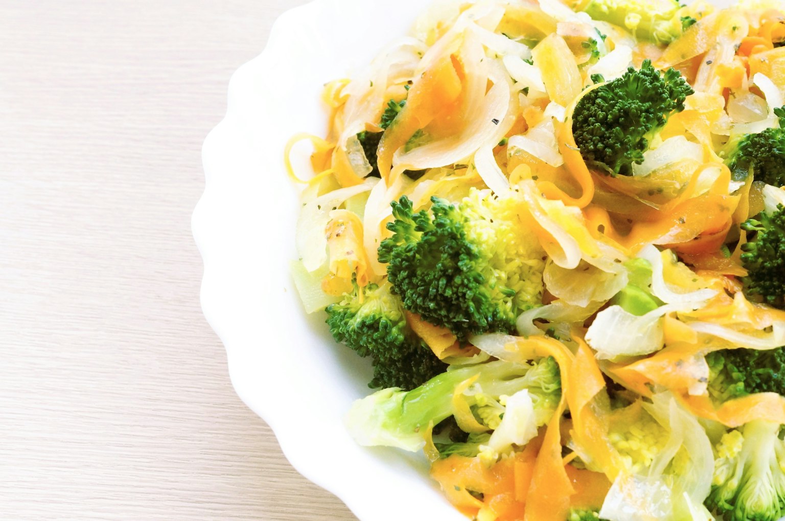 Ensalada fresca de brócoli y zanahorias servida en un tazón blanco