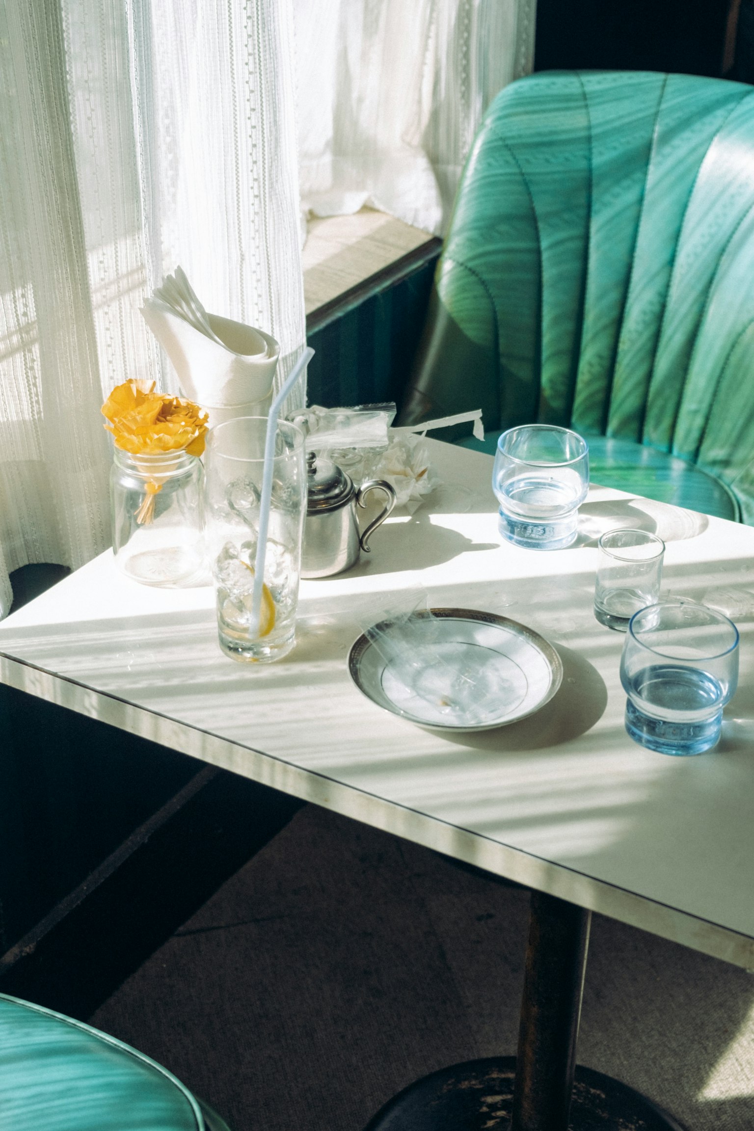 Intérieur d'un café avec une table contenant des verres d'eau et une petite assiette