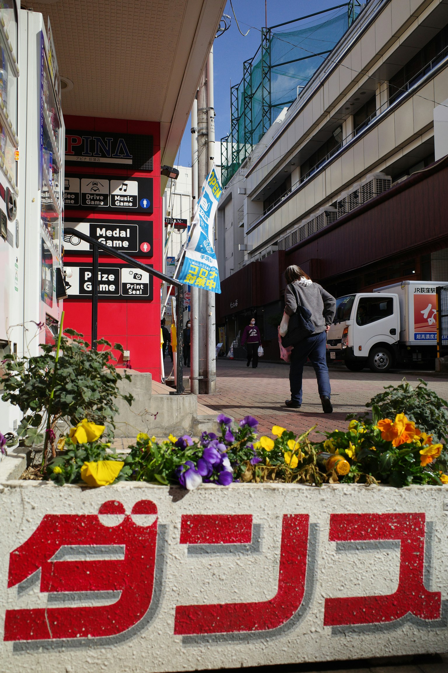 Street scene featuring a red sign and blooming flowers