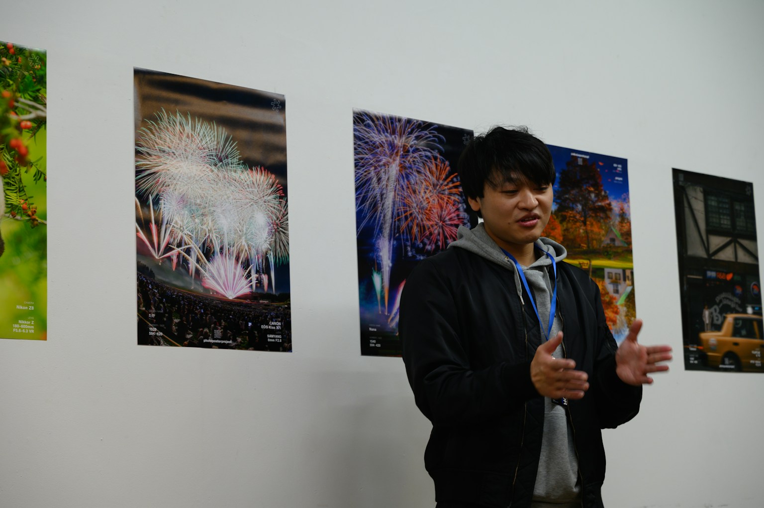 A man speaking in front of posters of fireworks on a wall