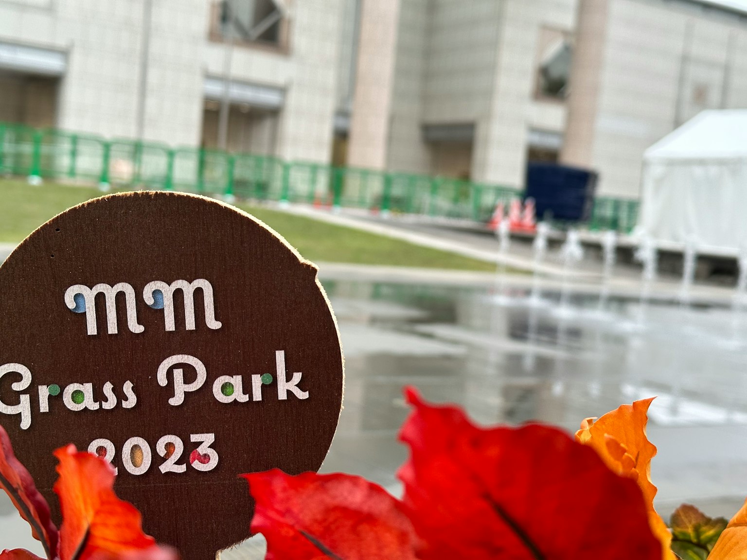 Biển chỉ dẫn cho MM Grass Park 2023 với lá mùa thu ở phía trước