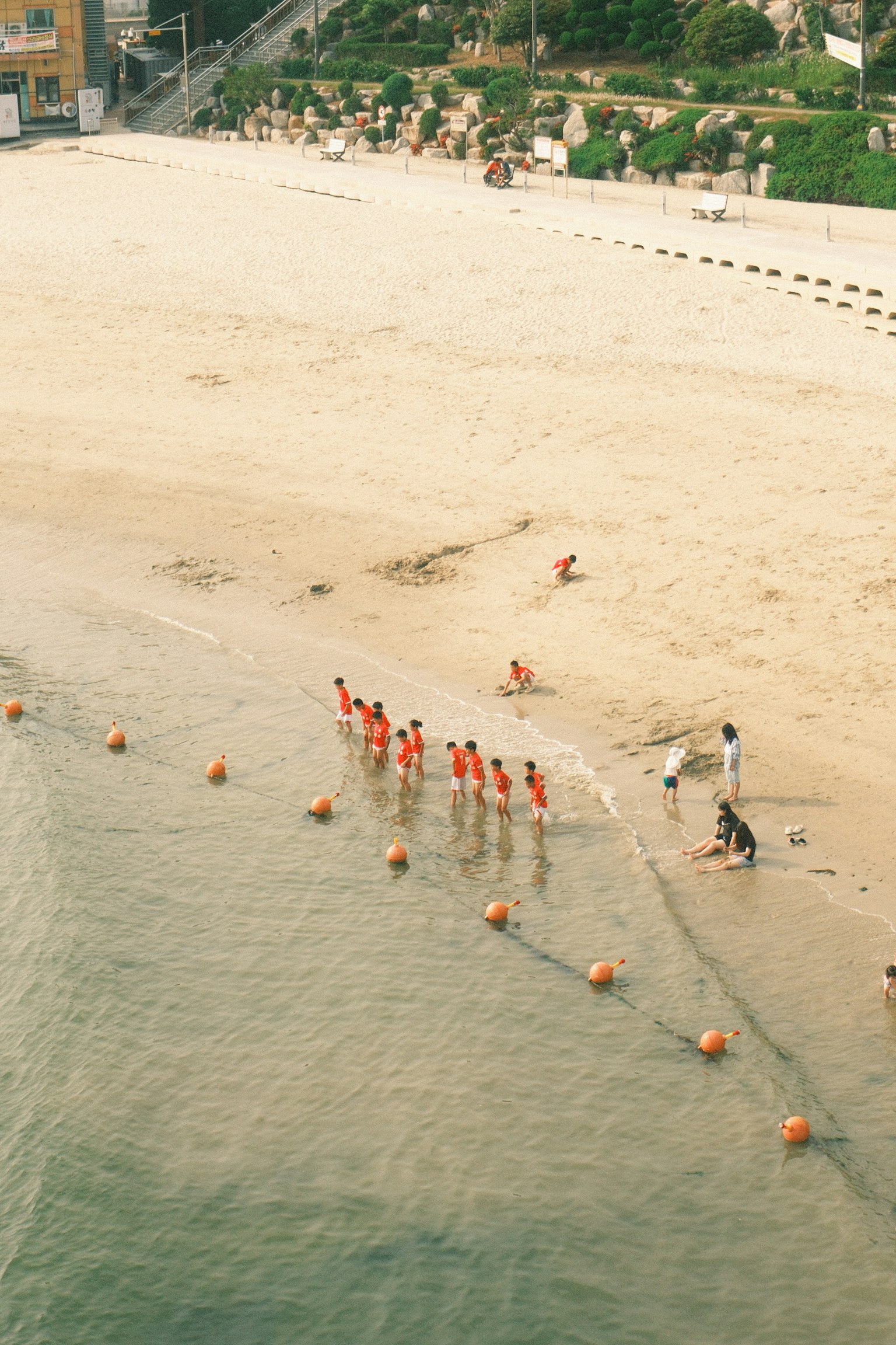 ผู้คนในเสื้อผ้าสีแดงเดินลงน้ำที่ชายหาด