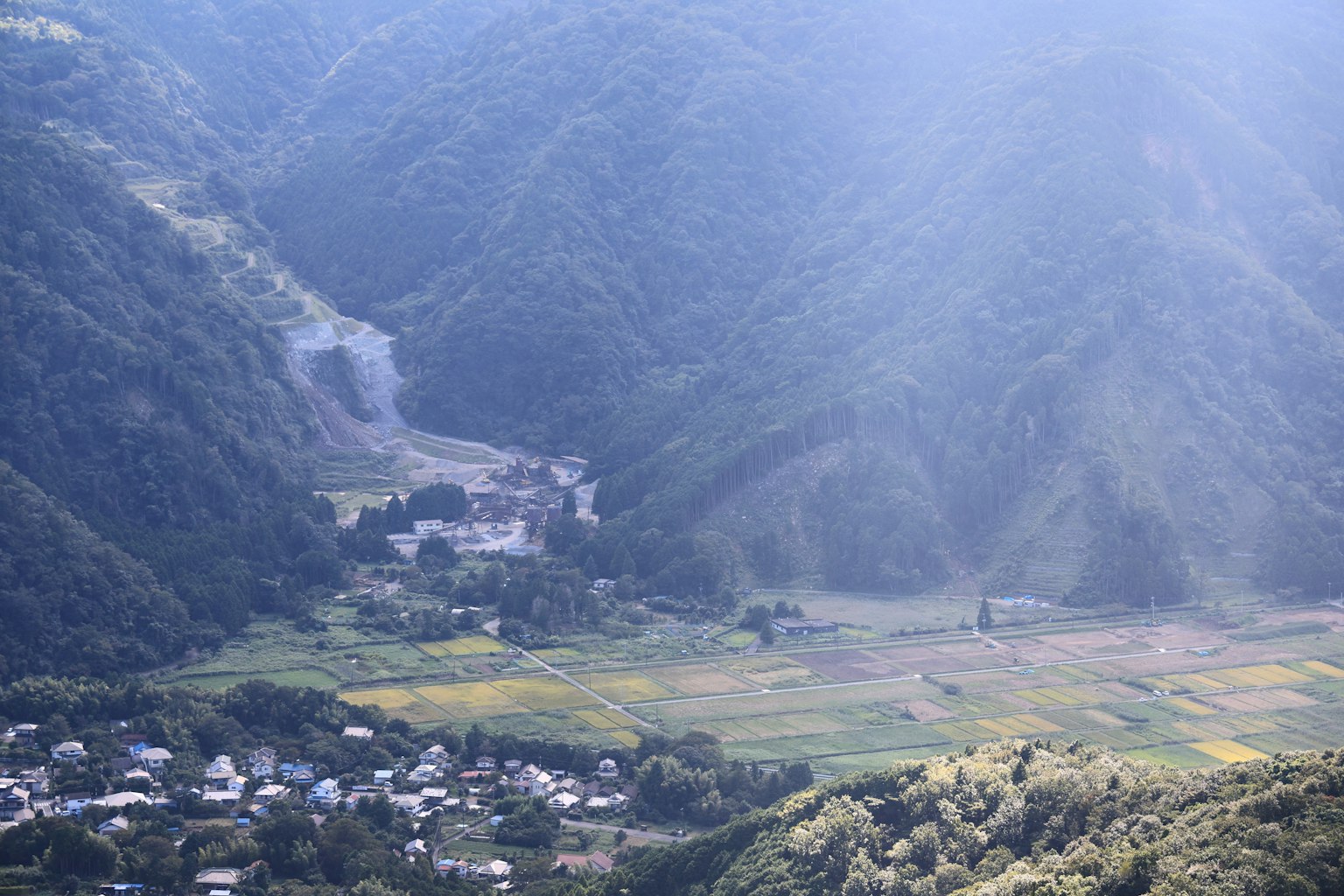 Un villaggio sereno circondato da montagne e campi verdi
