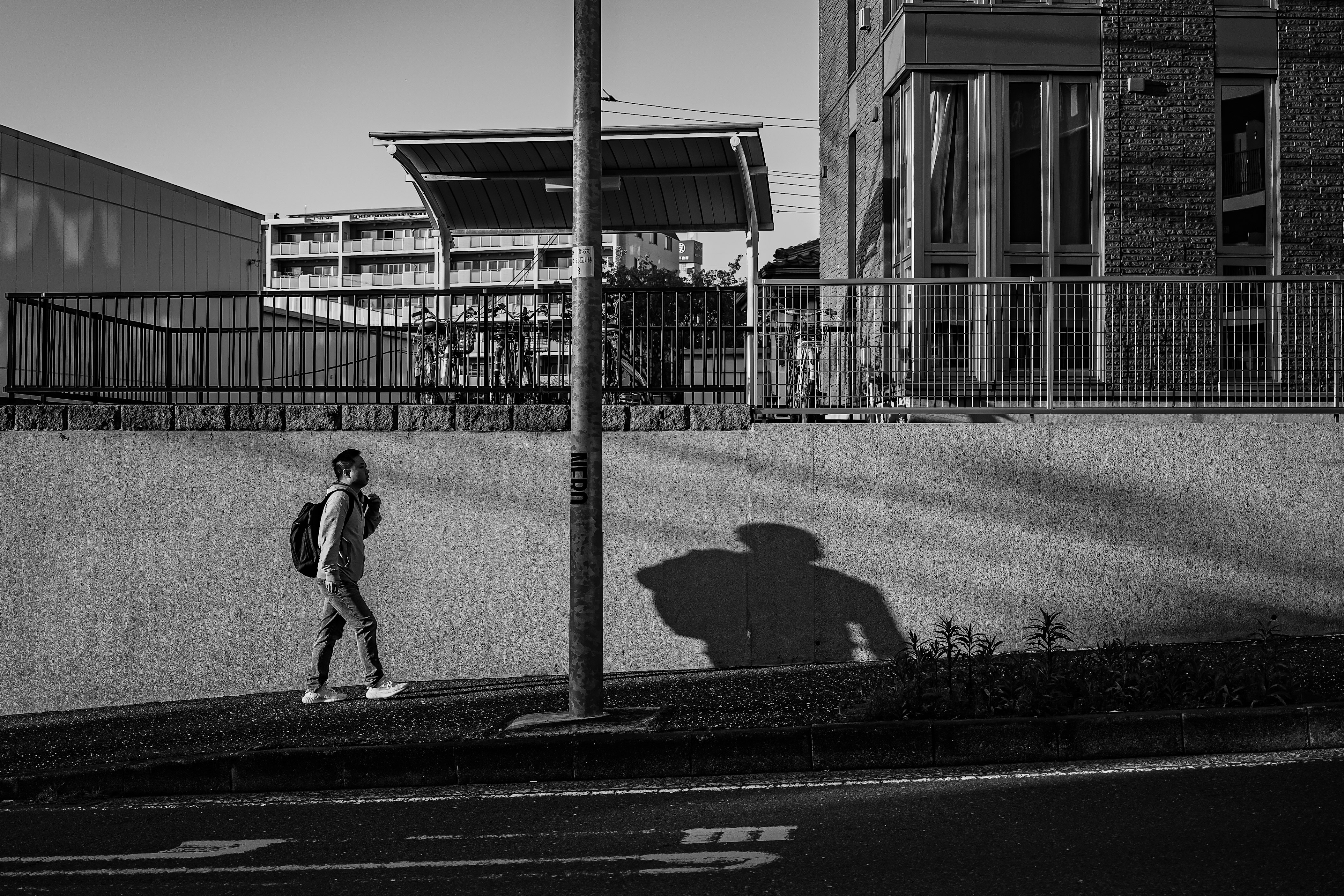 scène de rue urbaine avec une personne marchant le long d’un mur et de bâtiments