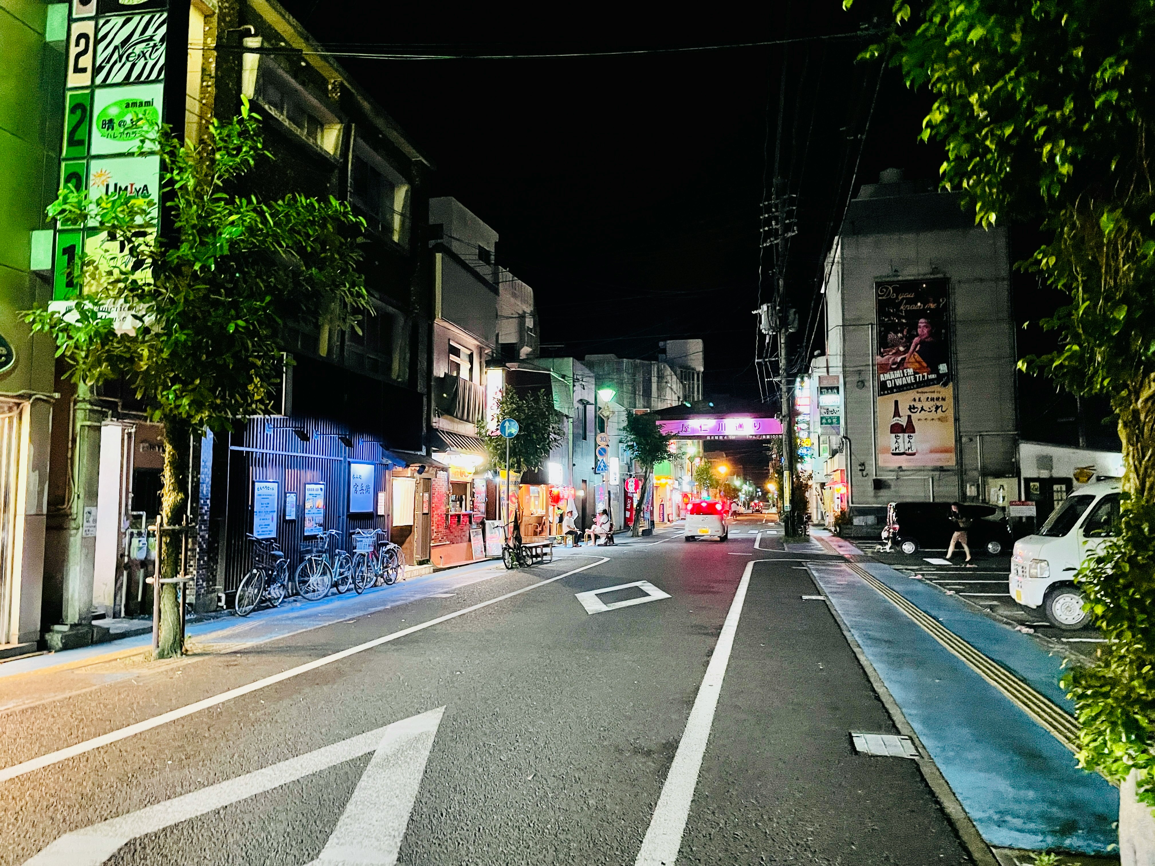 callejón nocturno con bicicletas estacionadas y letreros de neón
