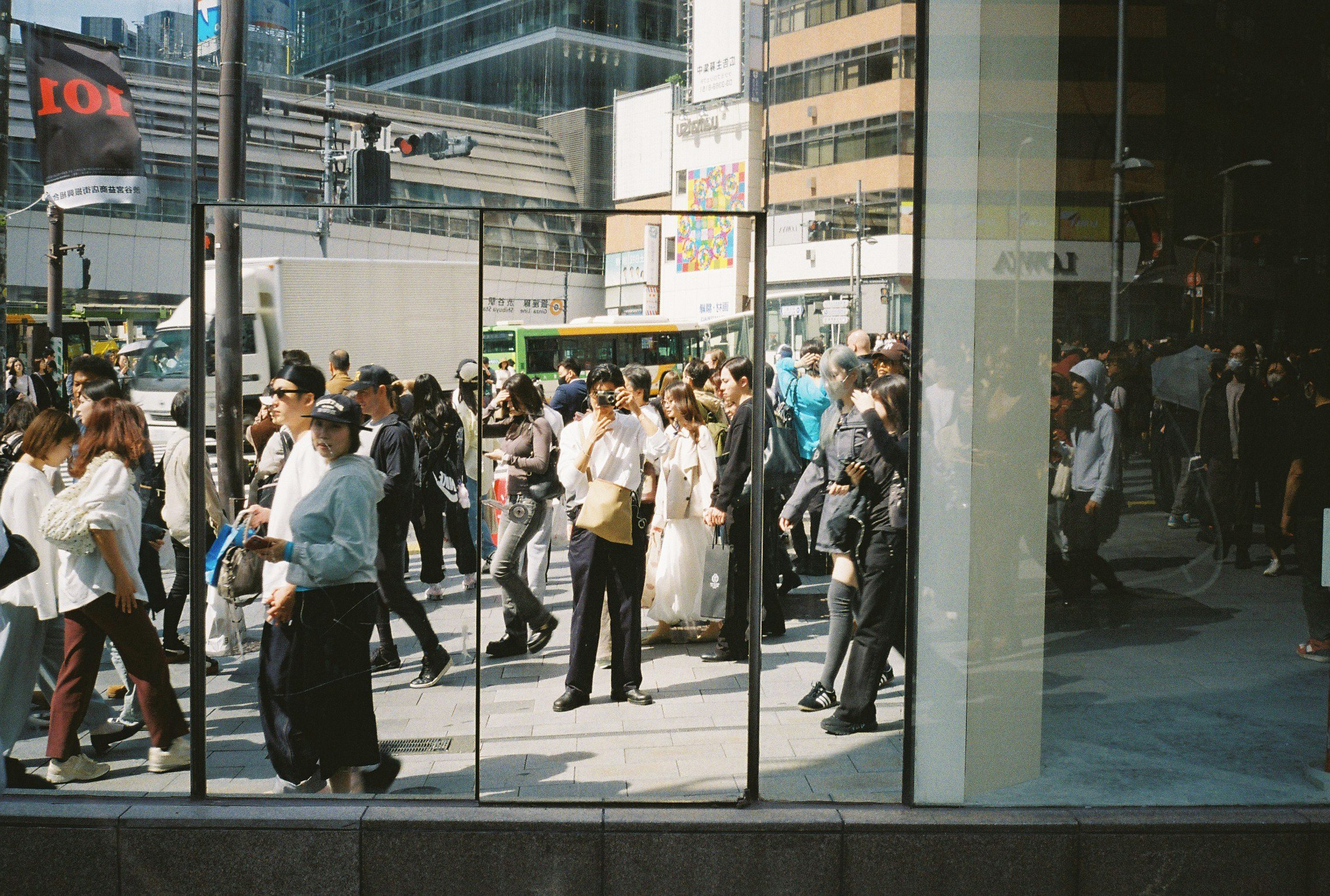 multitud de personas caminando frente a edificios de oficinas de vidrio