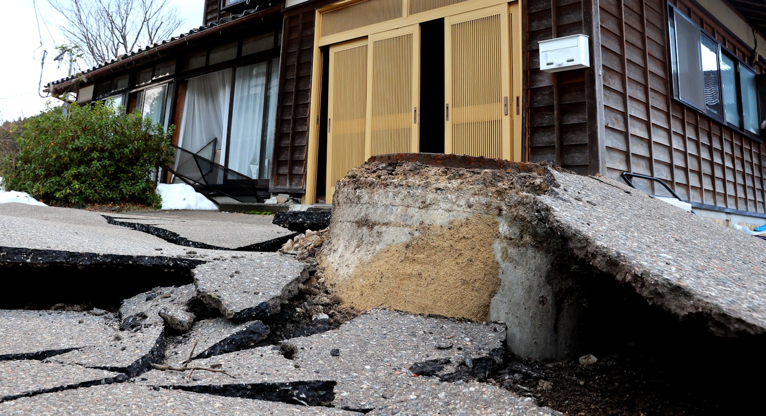 地震损坏的传统日本房屋外观和开裂的混凝土