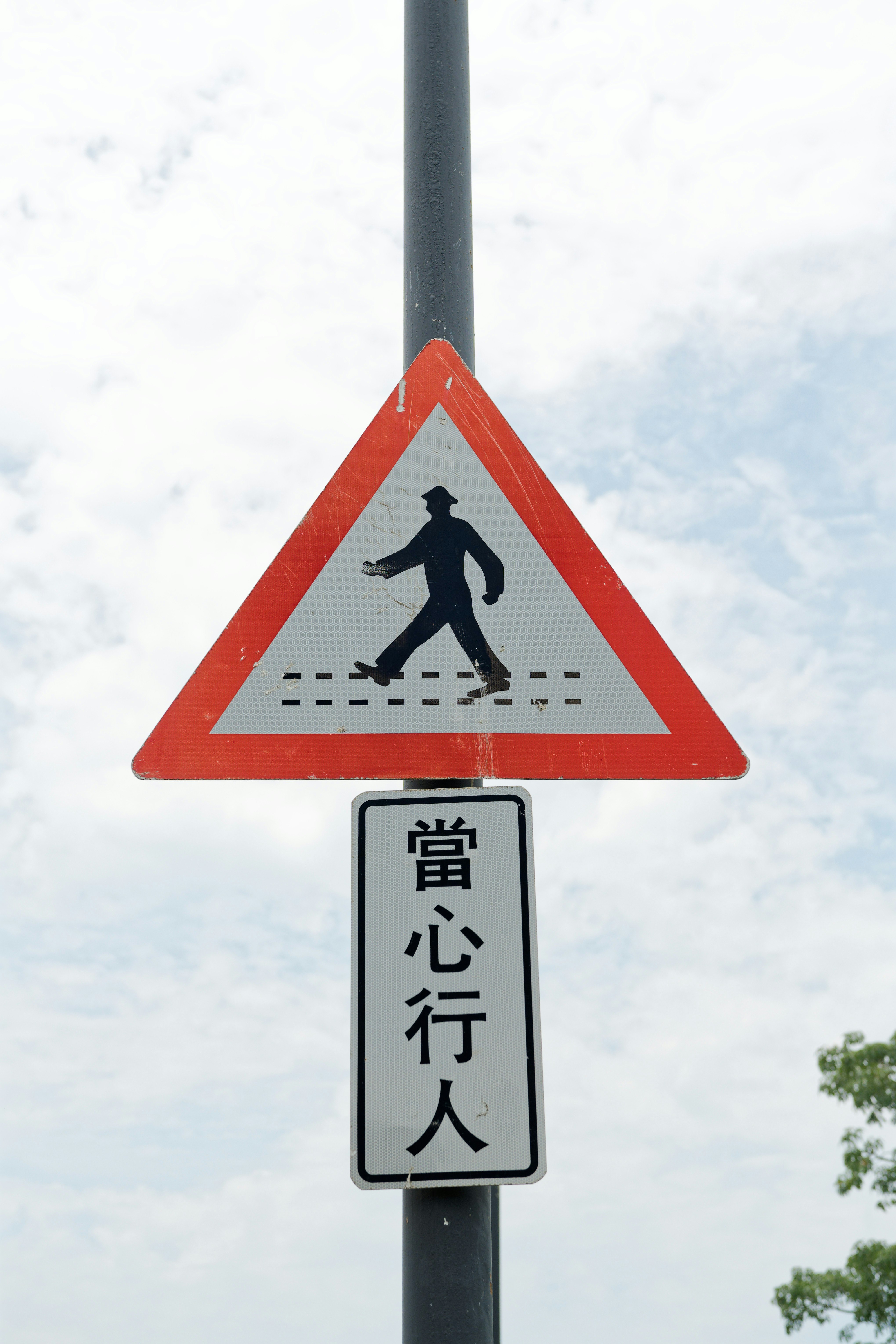 横断歩道のような注意標識と「当心行人」表示