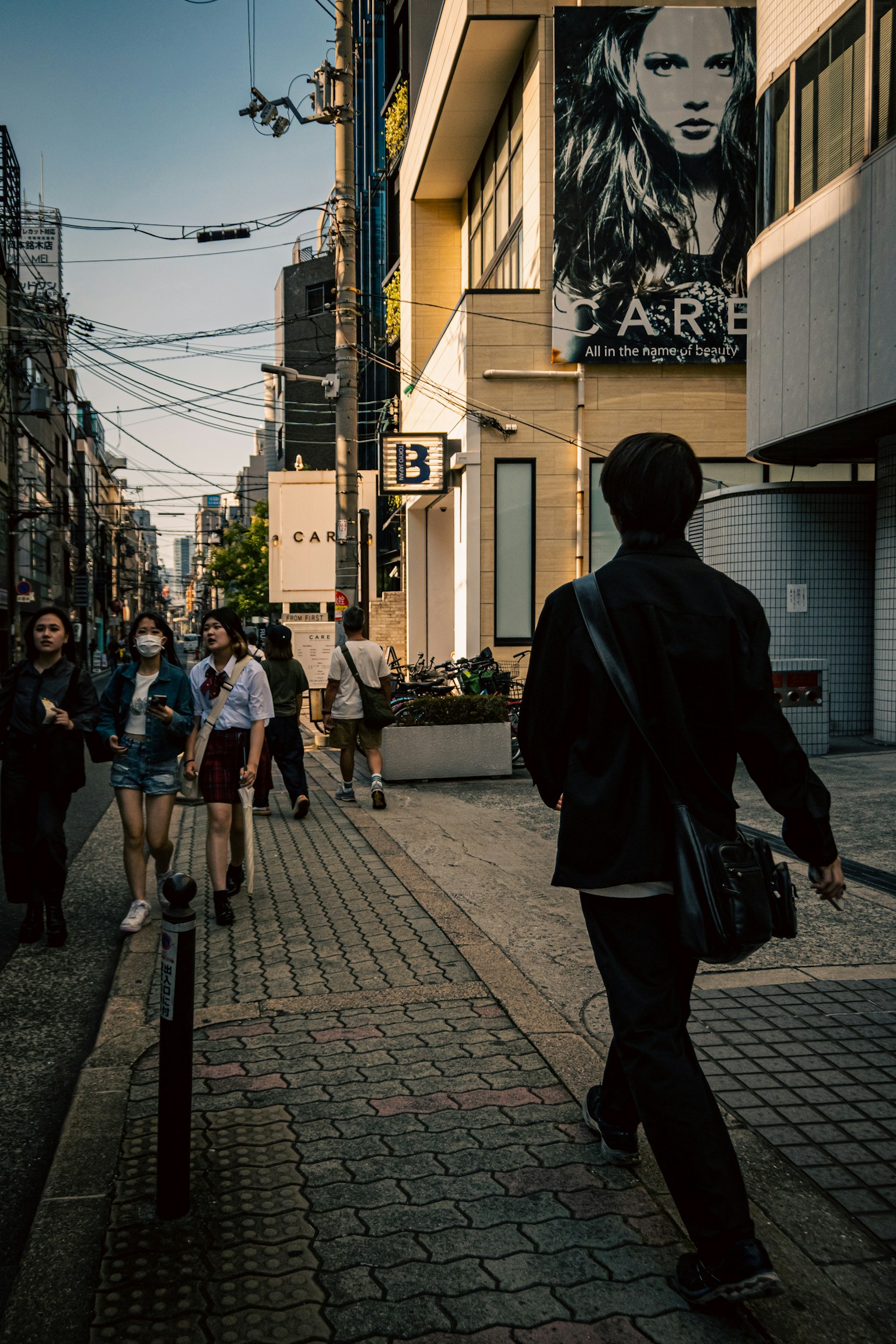 Straßenszene mit Fußgängern und einem Gebäude mit einer großen Werbung