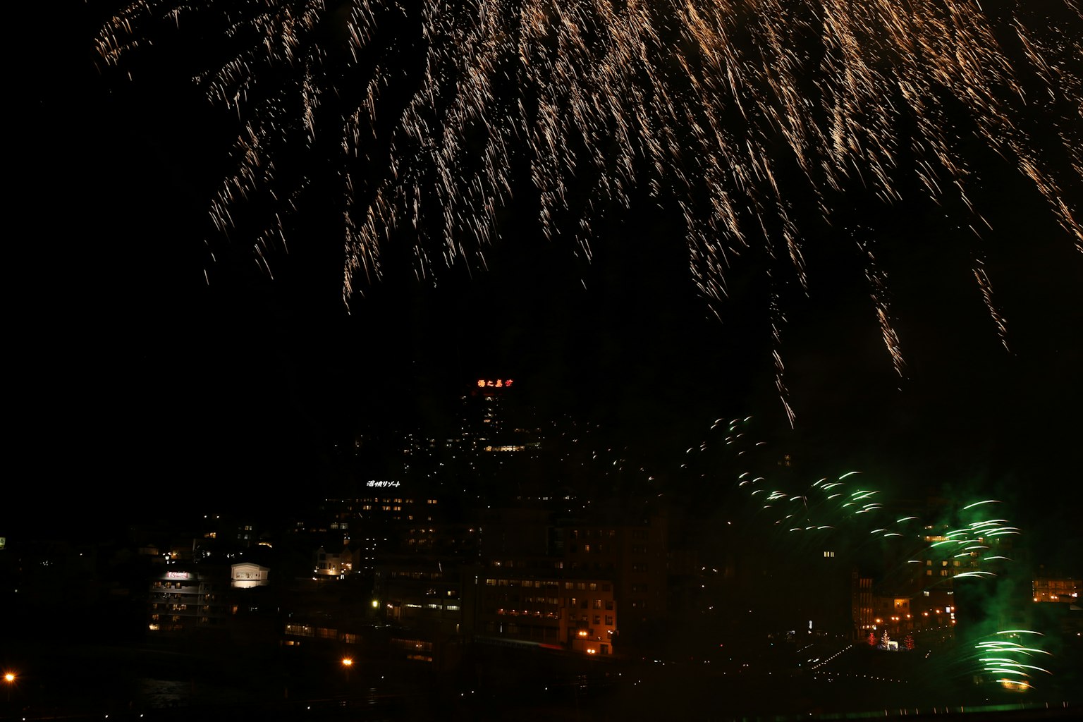 Fuochi d'artificio esplodono nel cielo notturno sopra lo skyline di una città