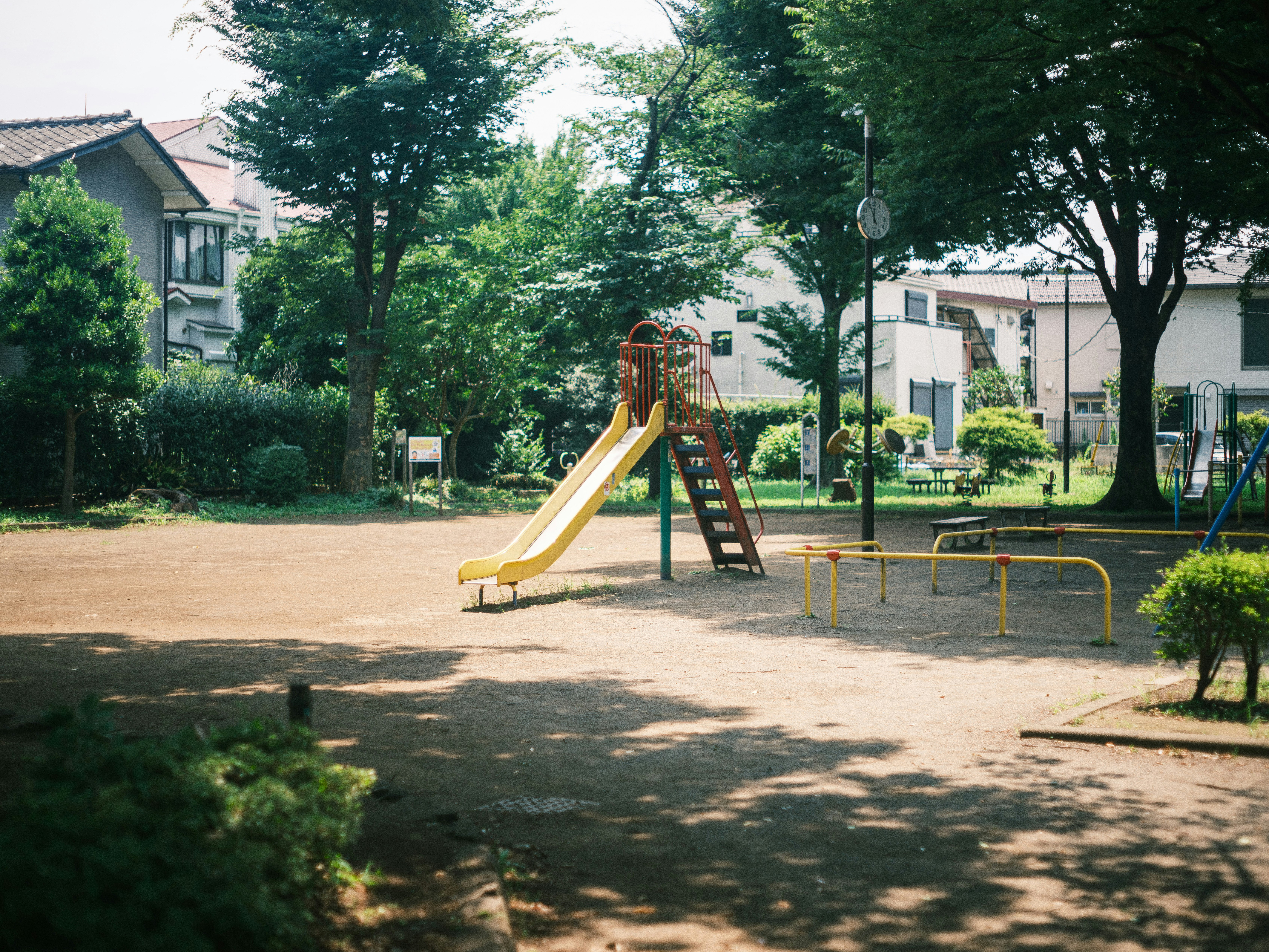 公園の遊具と芝生のある広場