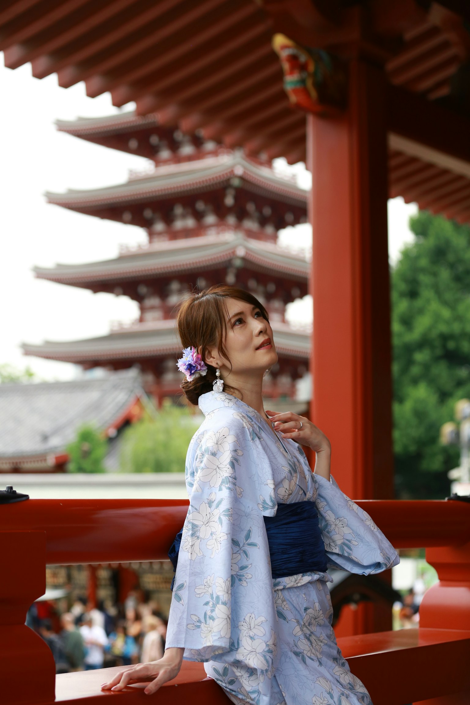 一位穿着传统和服的女性在背景中与五层宝塔和红色建筑合影