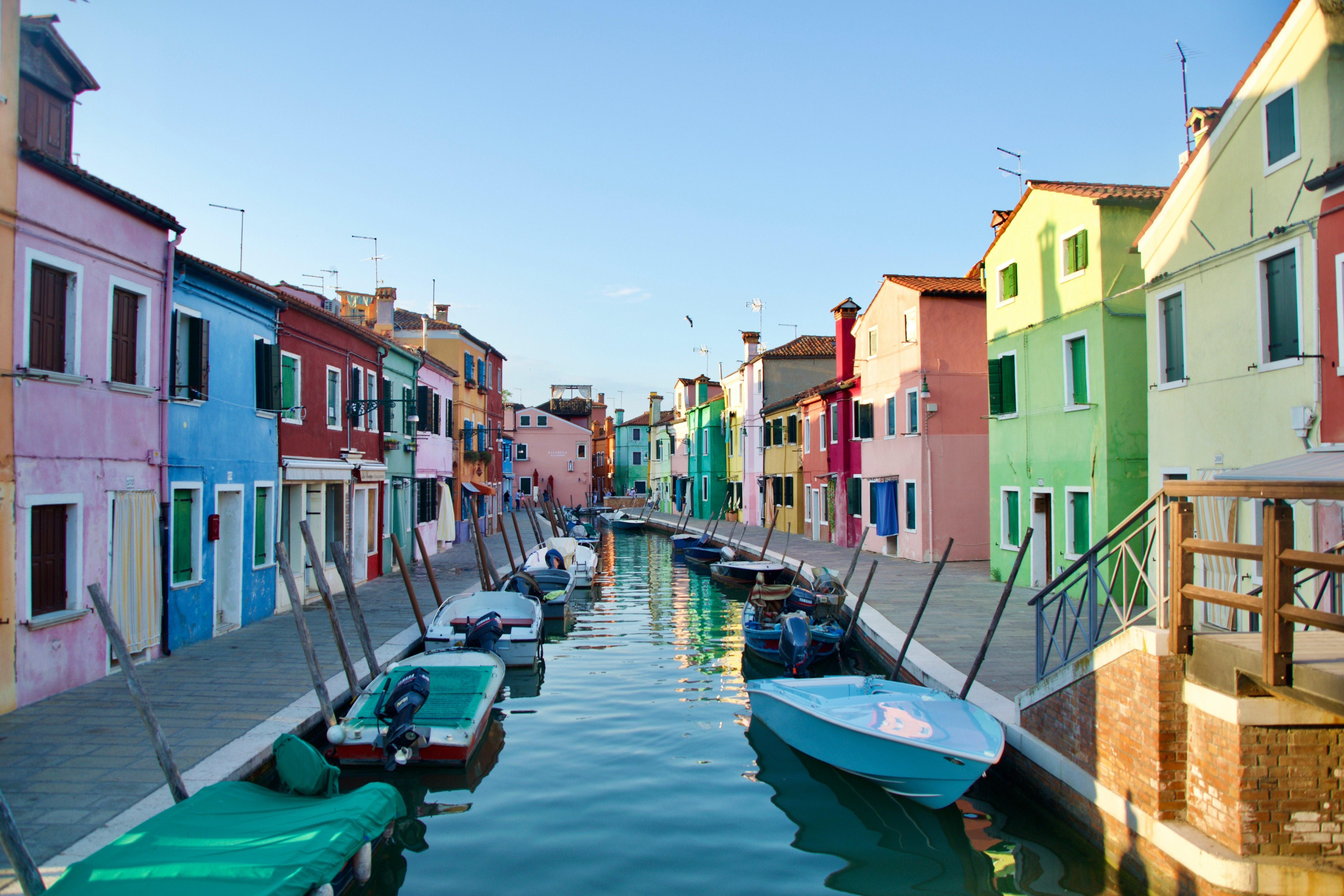 maisons colorées au bord du canal avec des bateaux amarrés dans une rue de ville