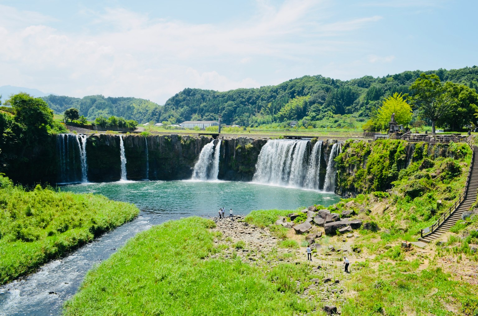 ทิวทัศน์ที่สวยงามของน้ำตกที่มีความเขียวขจีล้อมรอบ